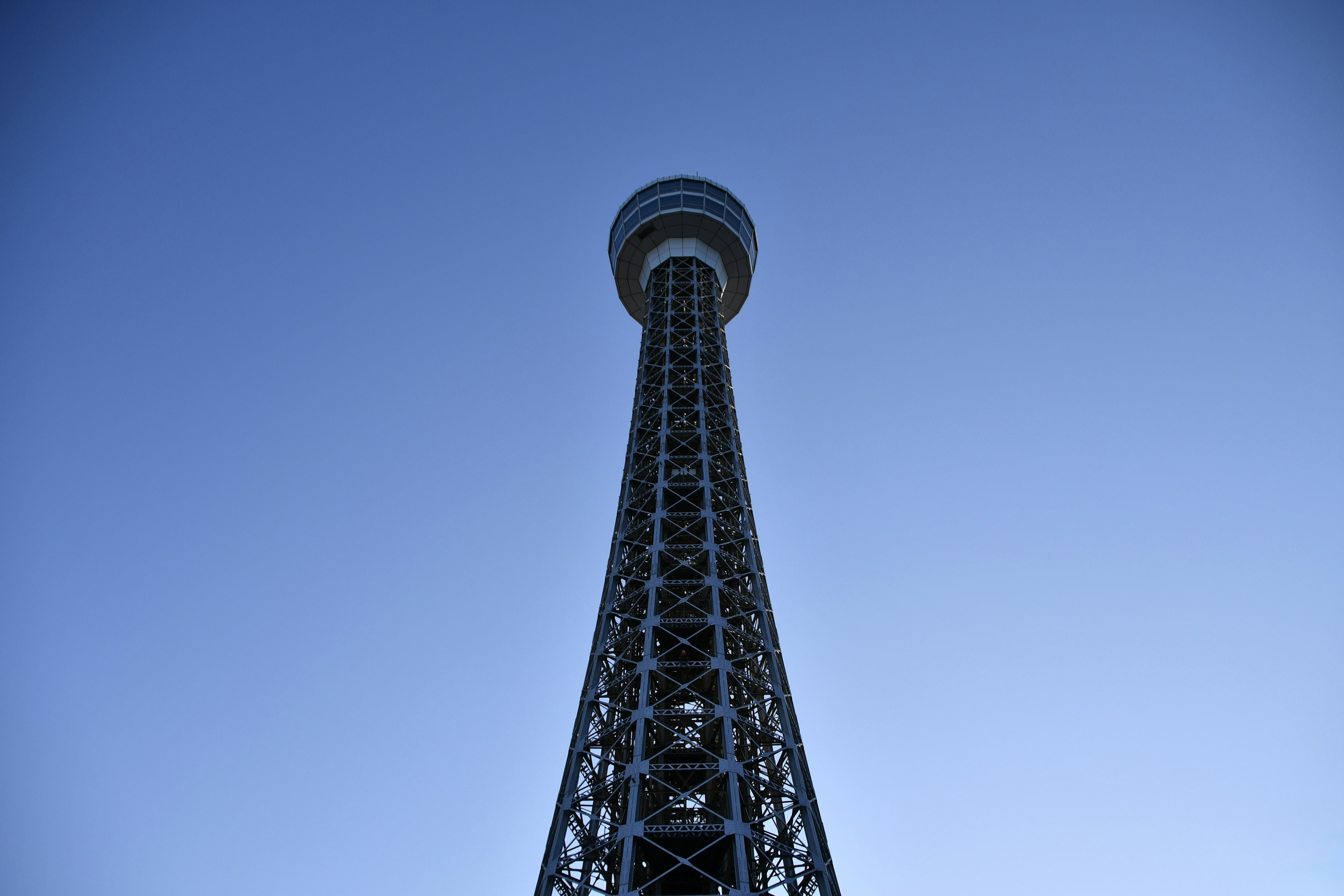 Blick auf einen hohen Turm von unten vor blauem Himmel