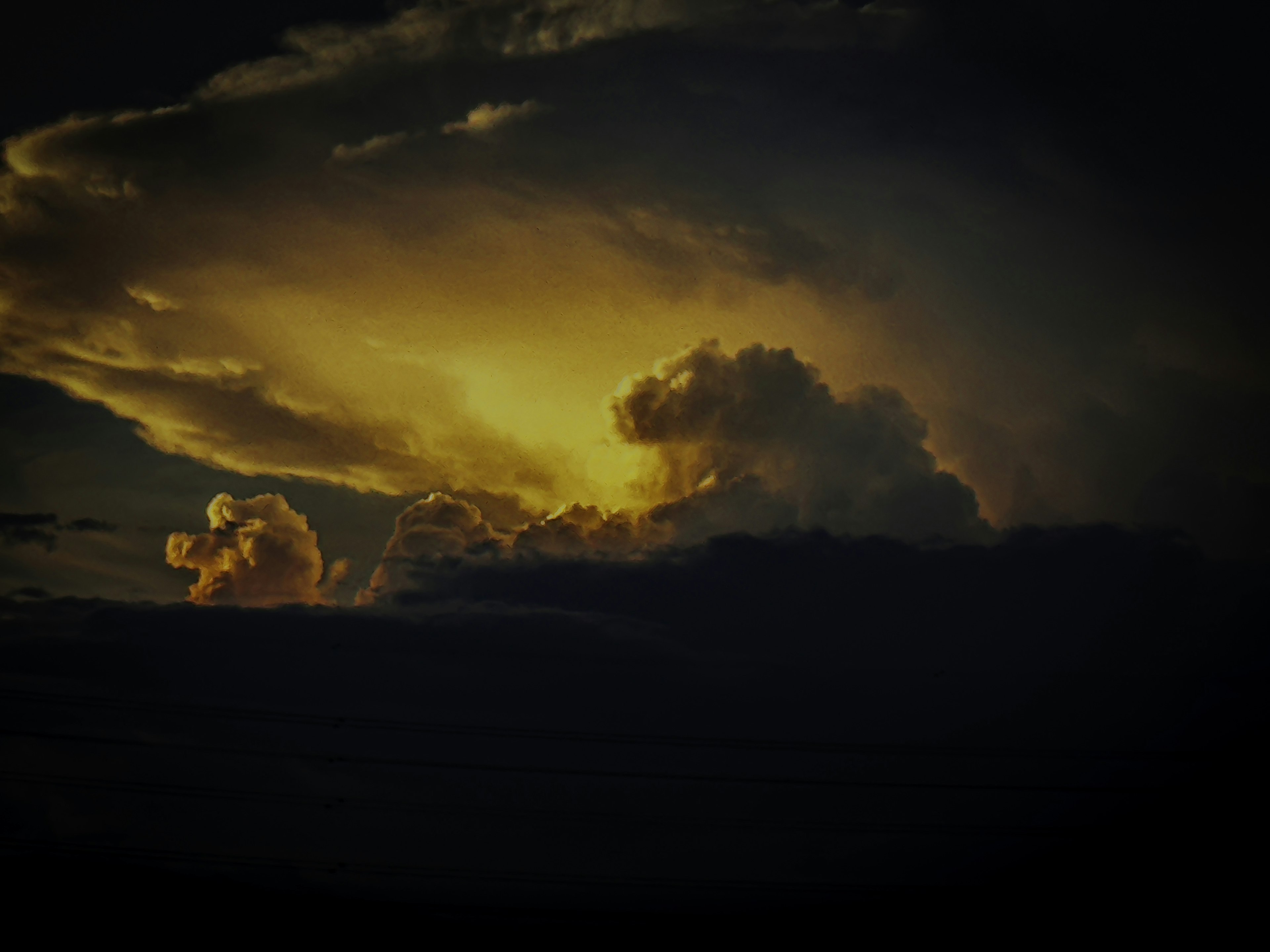 Leuchtende Wolken, erhellt von goldenem Licht gegen einen dunklen Himmel