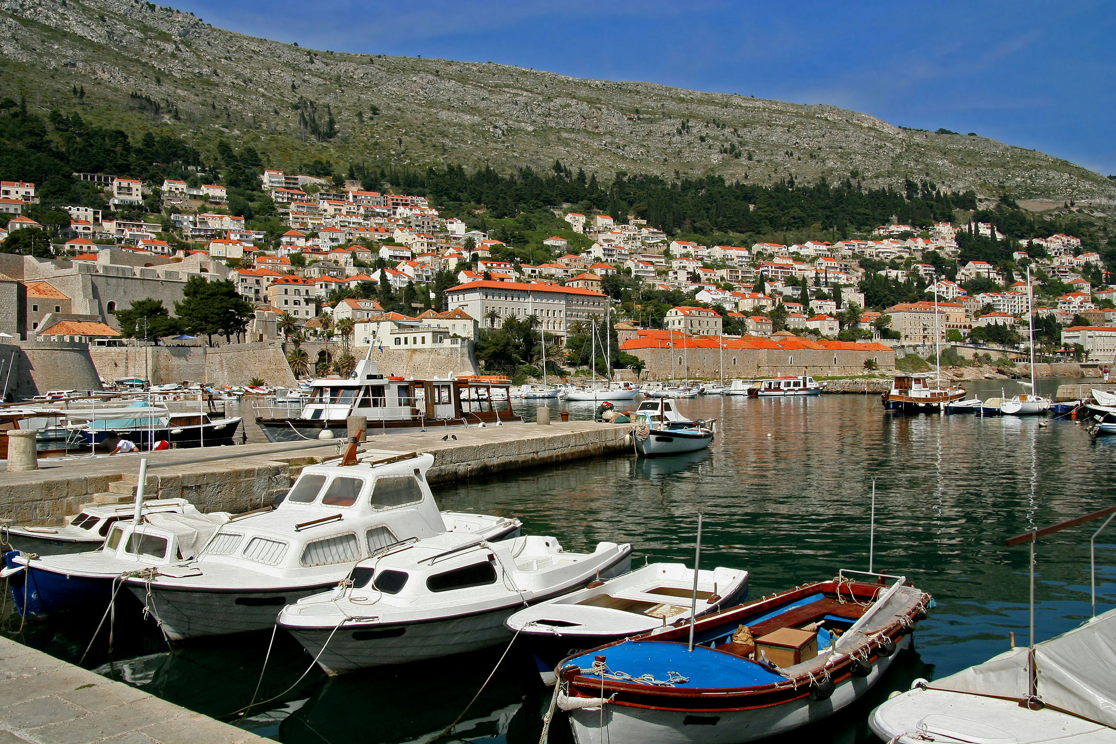 Bateaux amarrés dans un port pittoresque avec des montagnes verdoyantes en arrière-plan