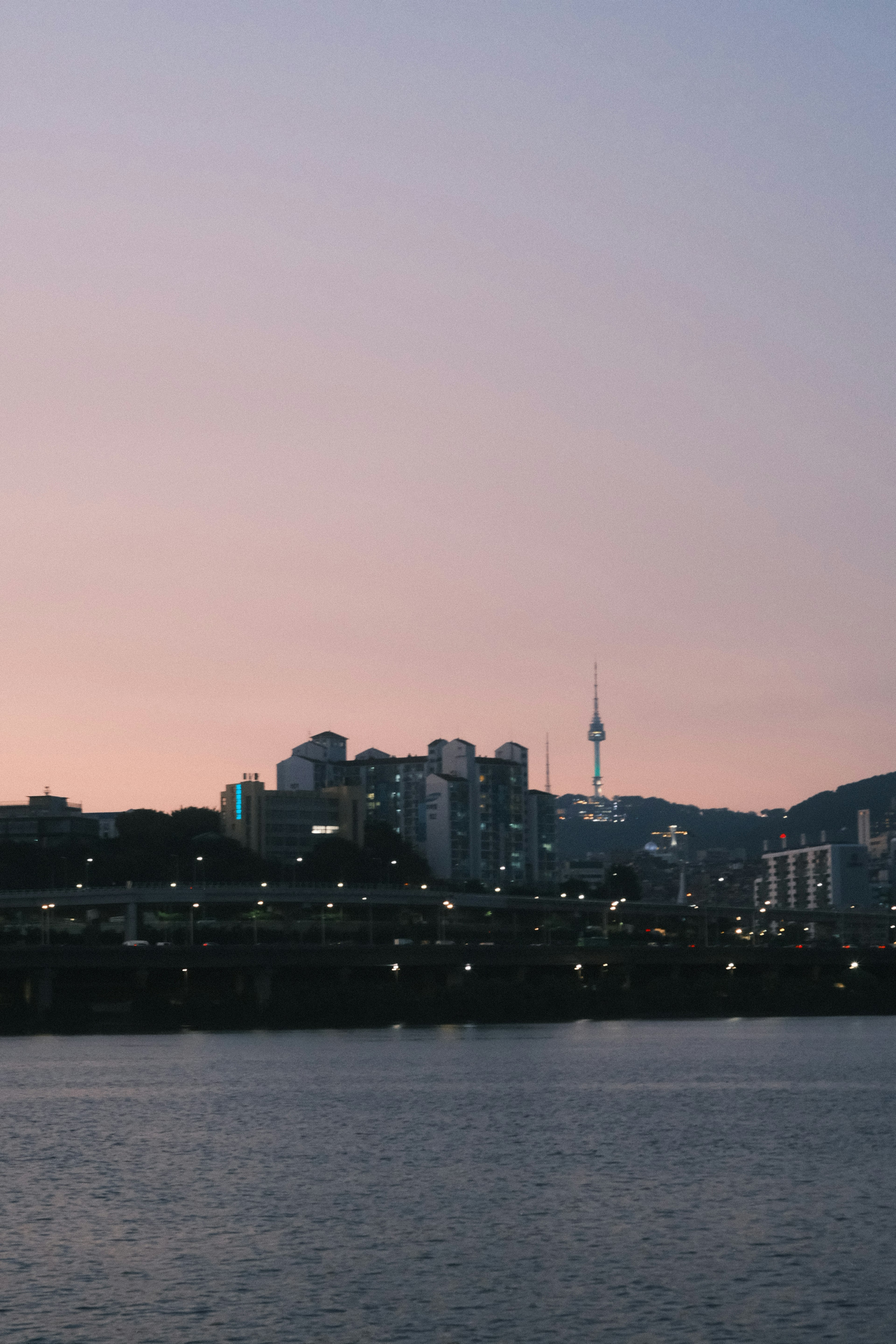 ソウルの夜景と漢江の静かな水面が見える美しい夕暮れ