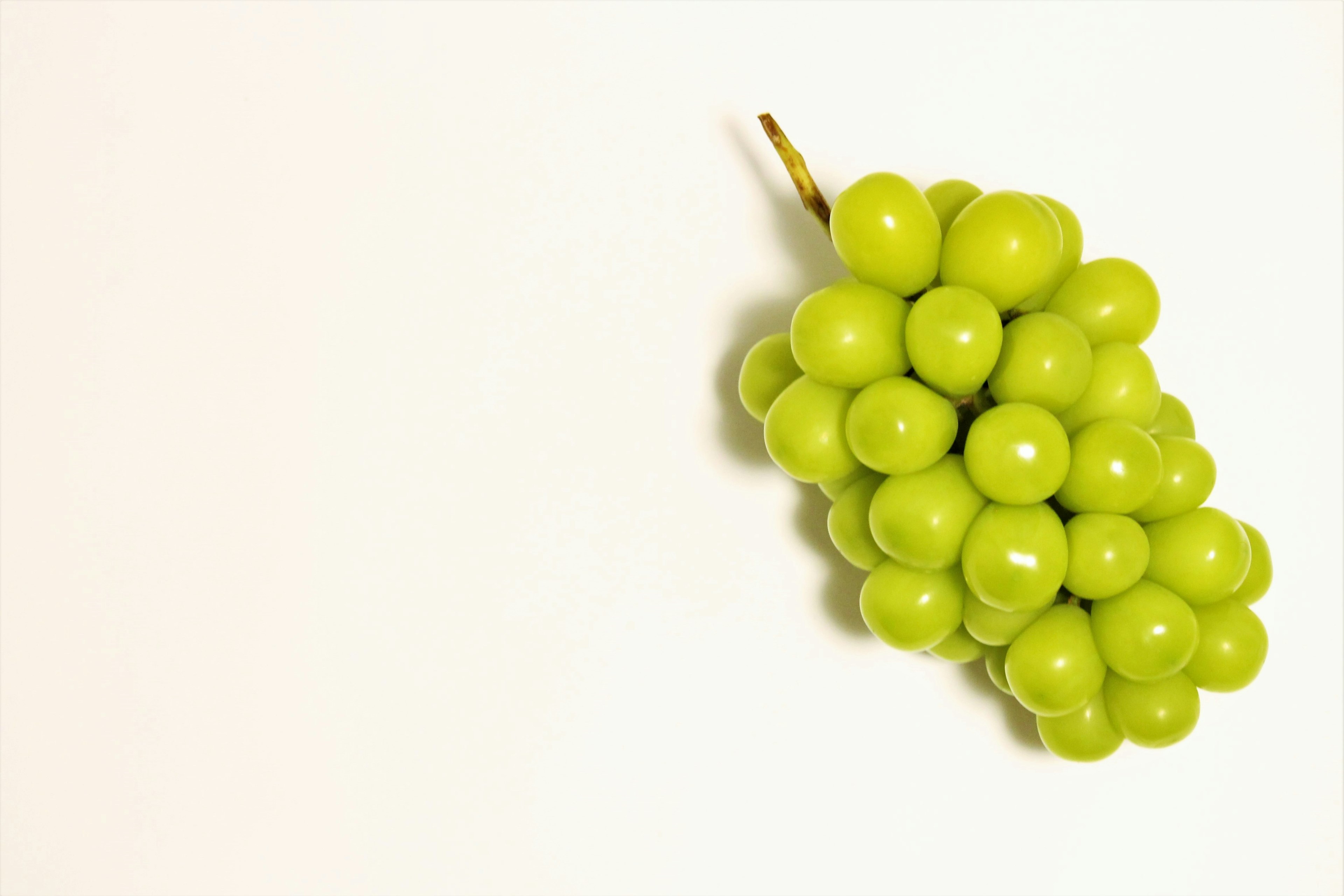 A cluster of green grapes on a white background