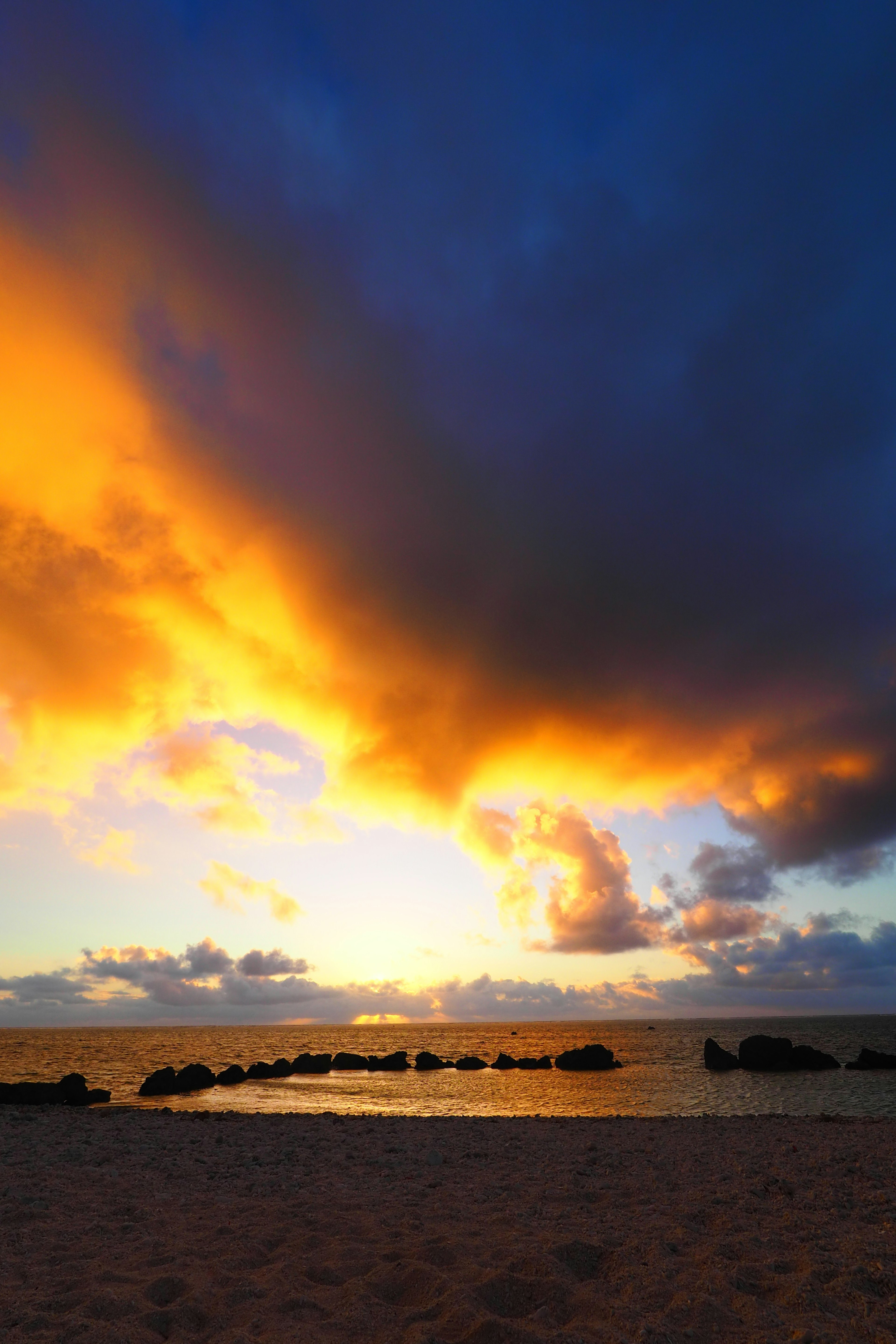 Beautiful sunset with vibrant orange and blue clouds over the ocean