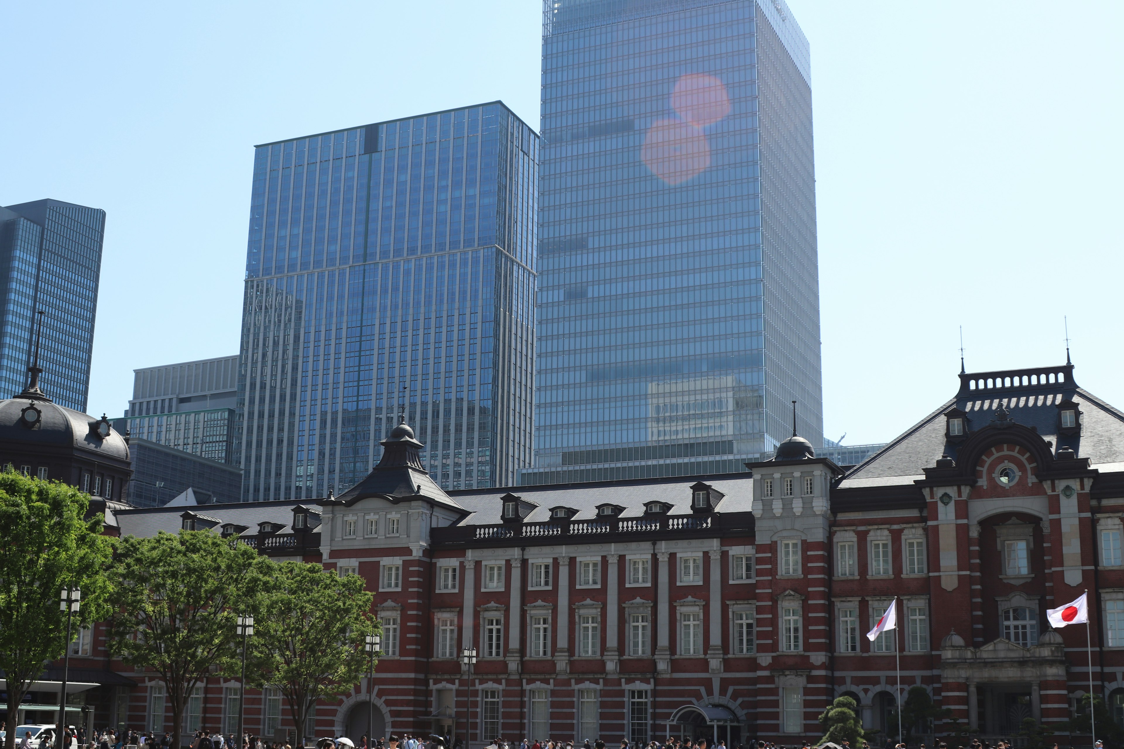 Contrasto tra la stazione di Tokyo e grattacieli in cielo sereno