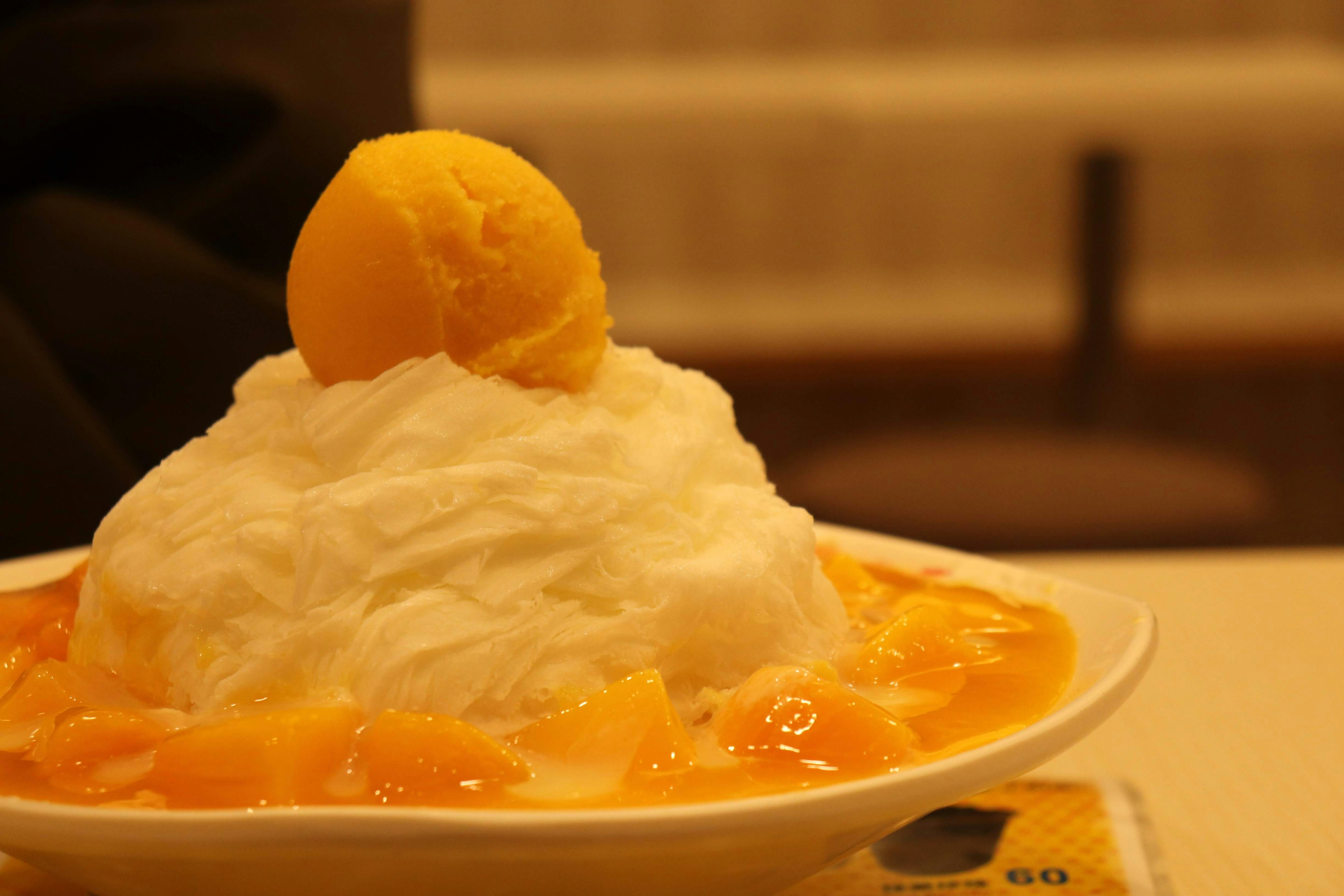 Glace pilée surmontée de sorbet à la mangue et de sauce aux fruits