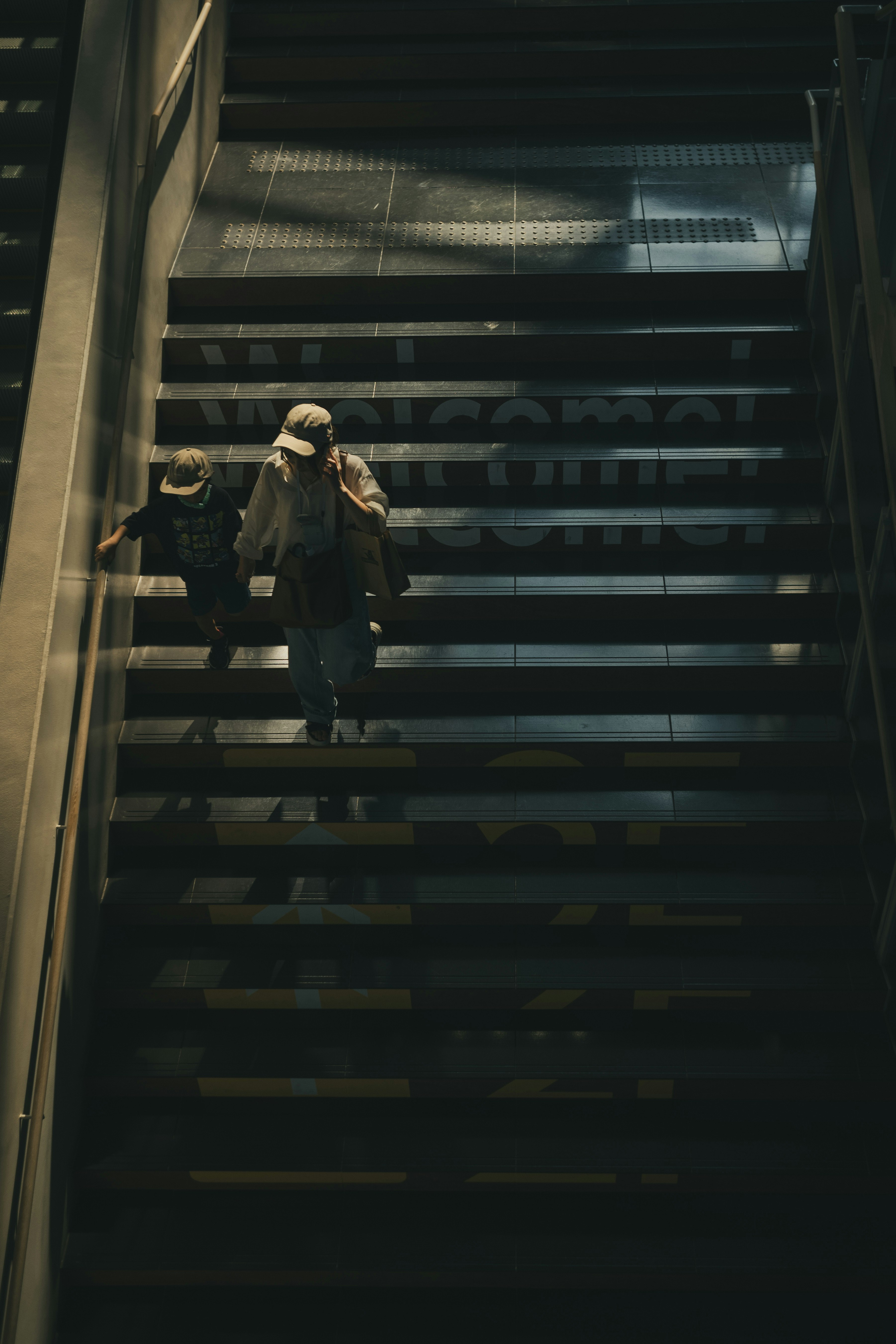 Silhouette von zwei Personen, die eine dunkle Treppe hinaufsteigen