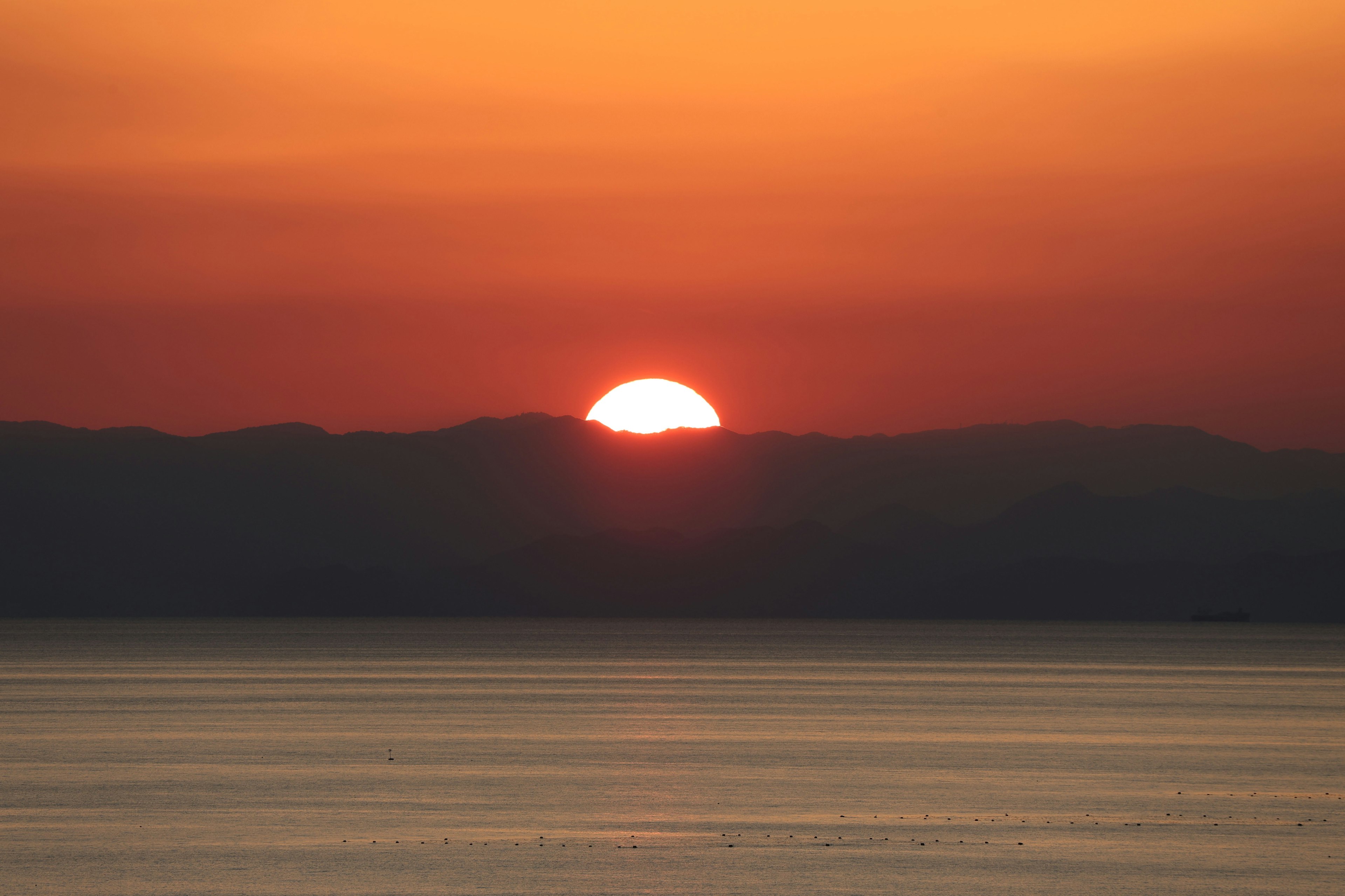 夕日が山の上に沈む美しい風景