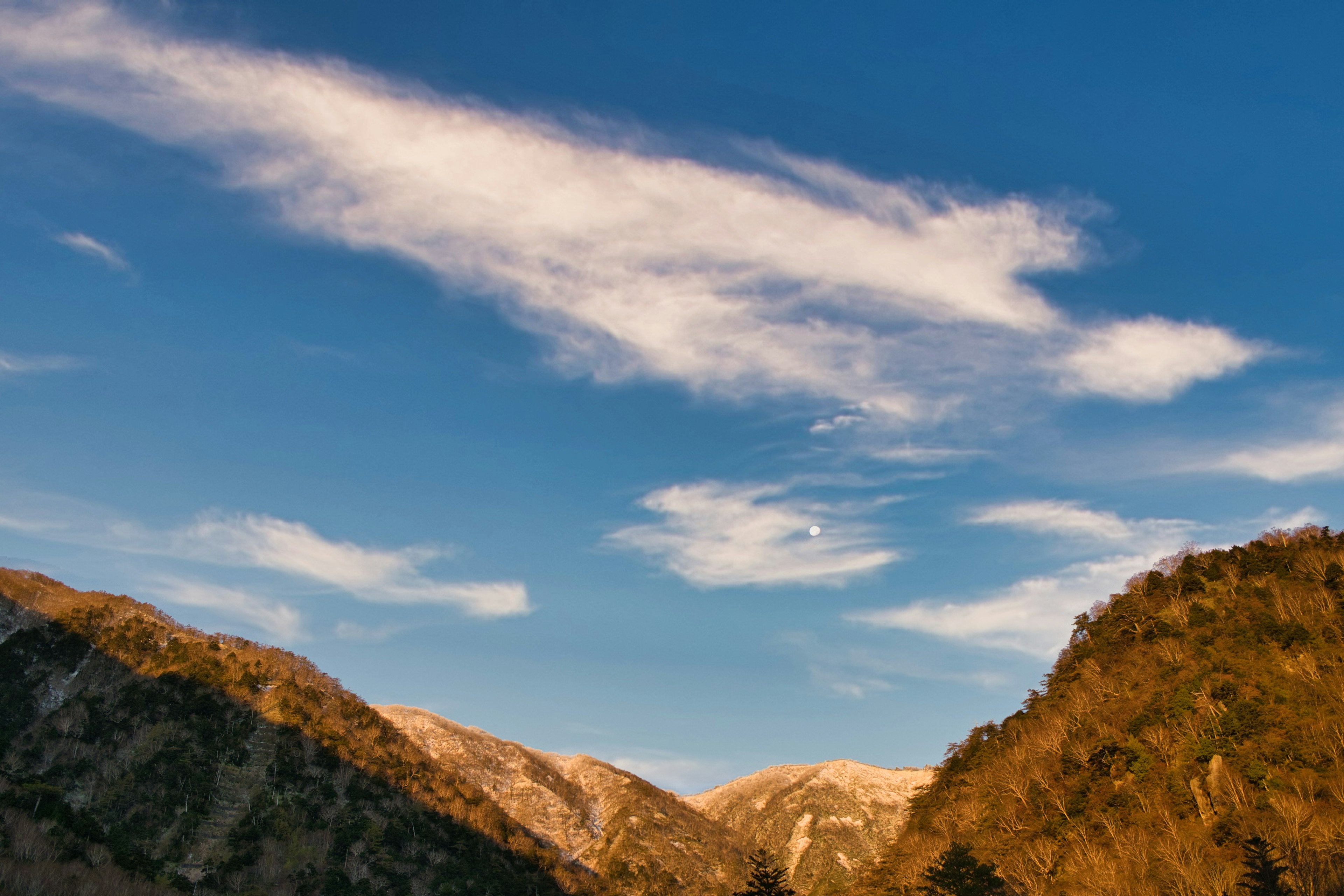 Mountain landscape surrounded by blue sky and white clouds