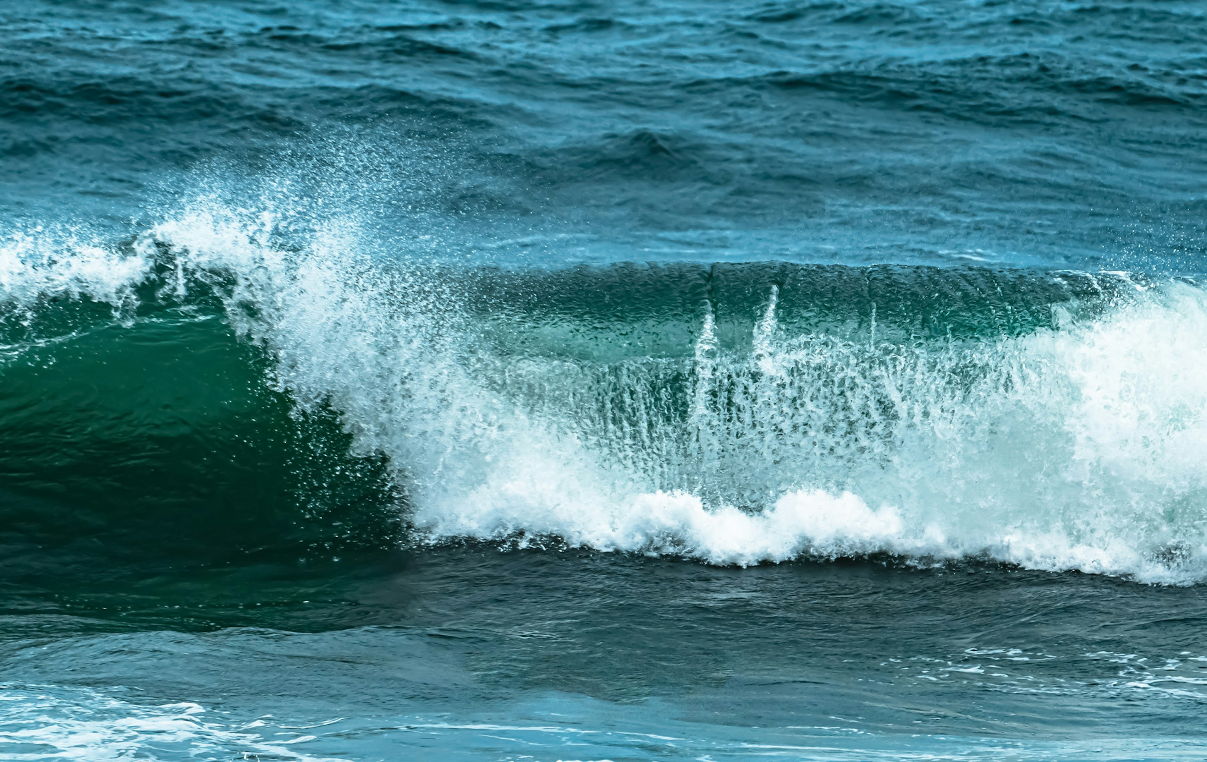 Vagues bleues de l'océan se brisant avec de la mousse blanche