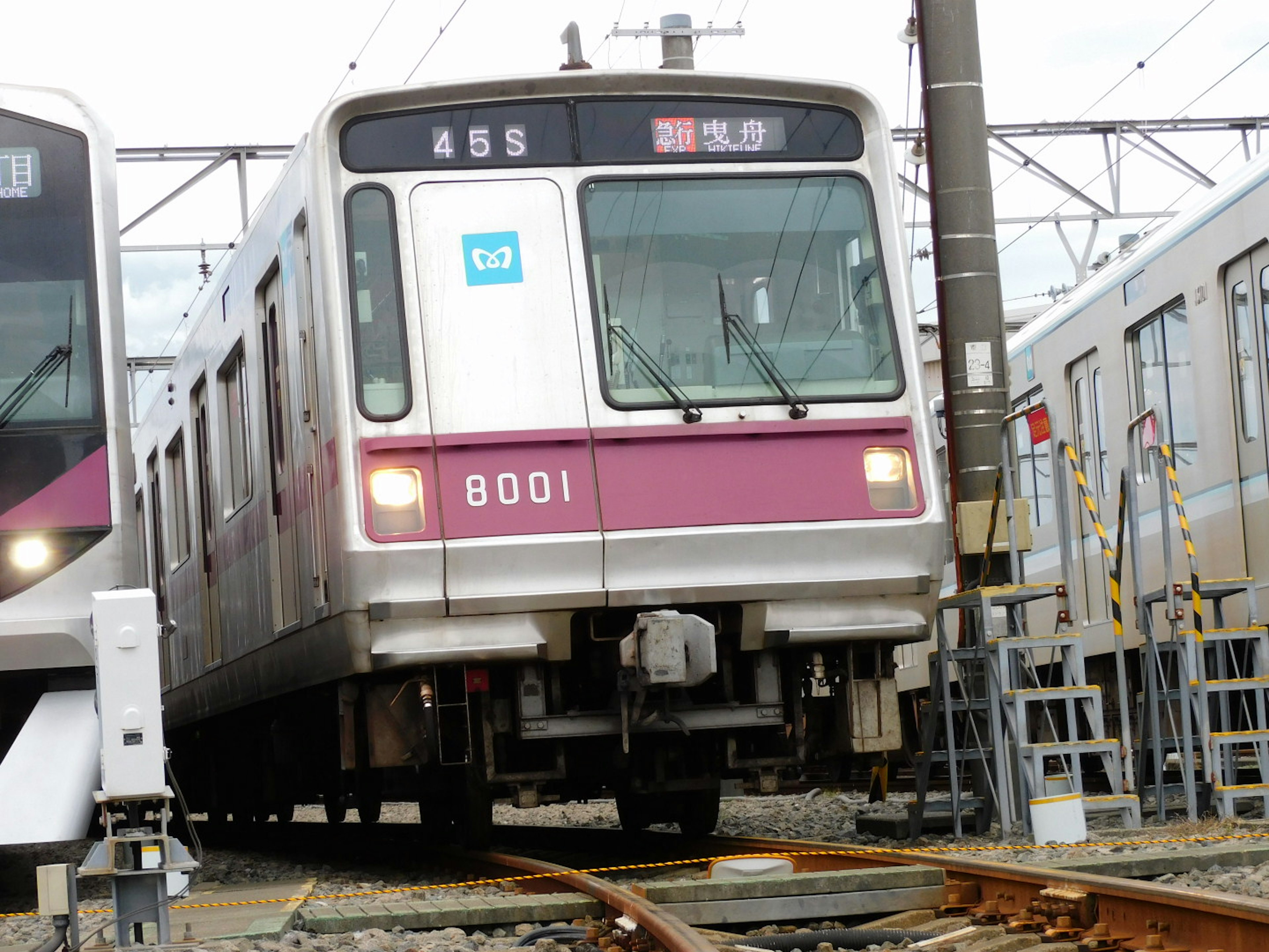 Train tournant sur les rails véhicule blanc et violet numéro 8001