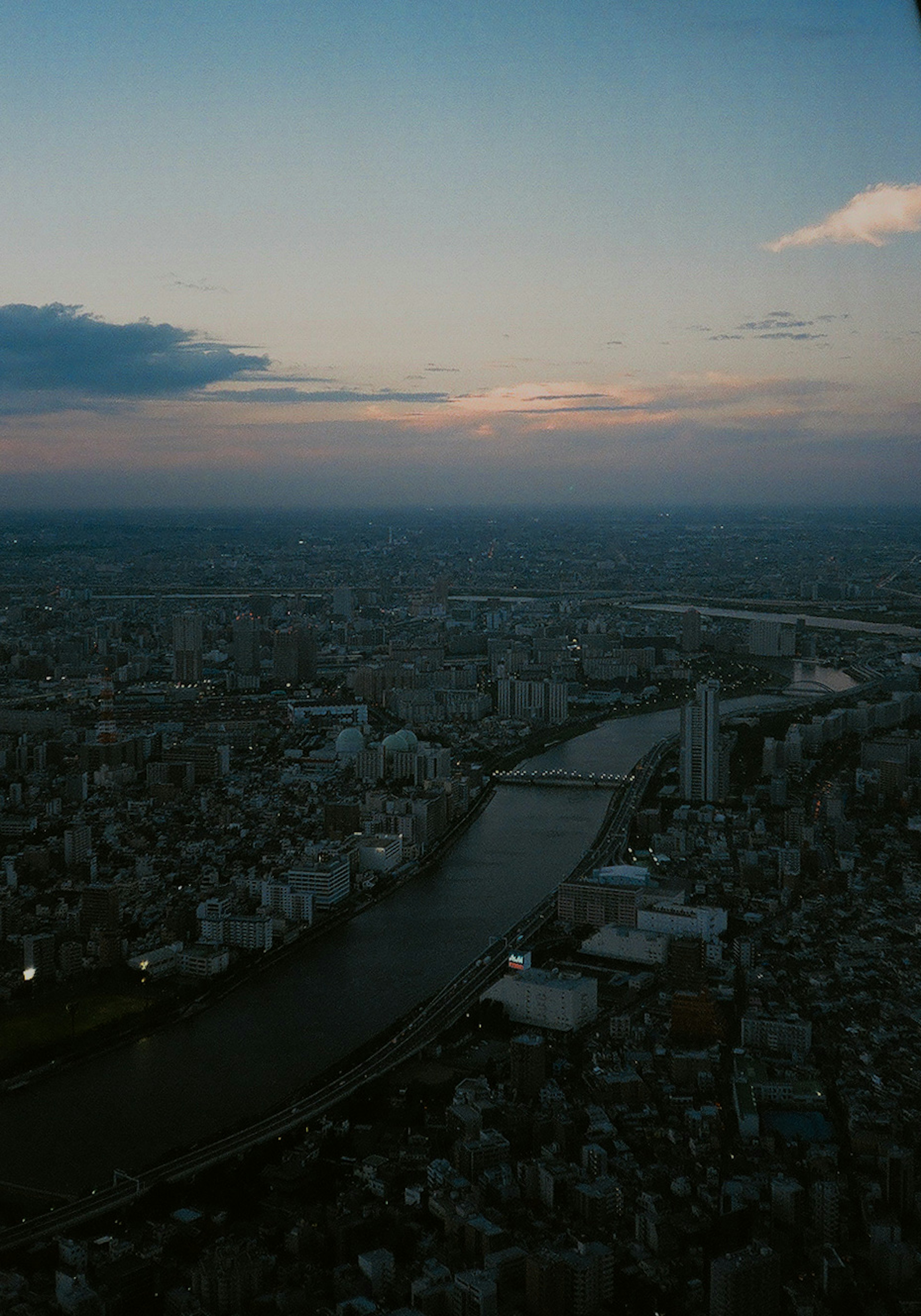 Vista aérea de una ciudad al atardecer con un río serpenteante