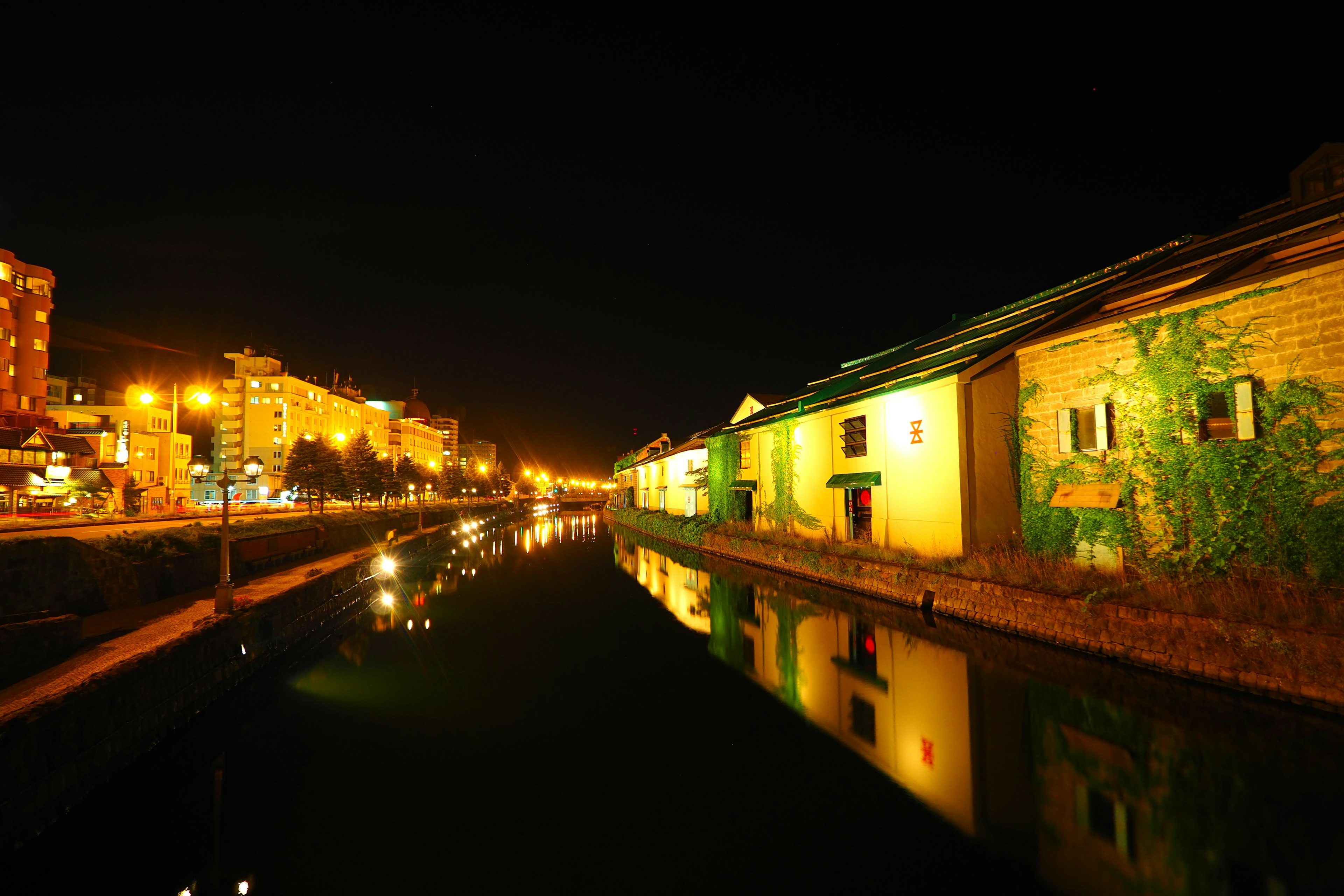 Vista nocturna de edificios a lo largo del canal con luces reflejadas