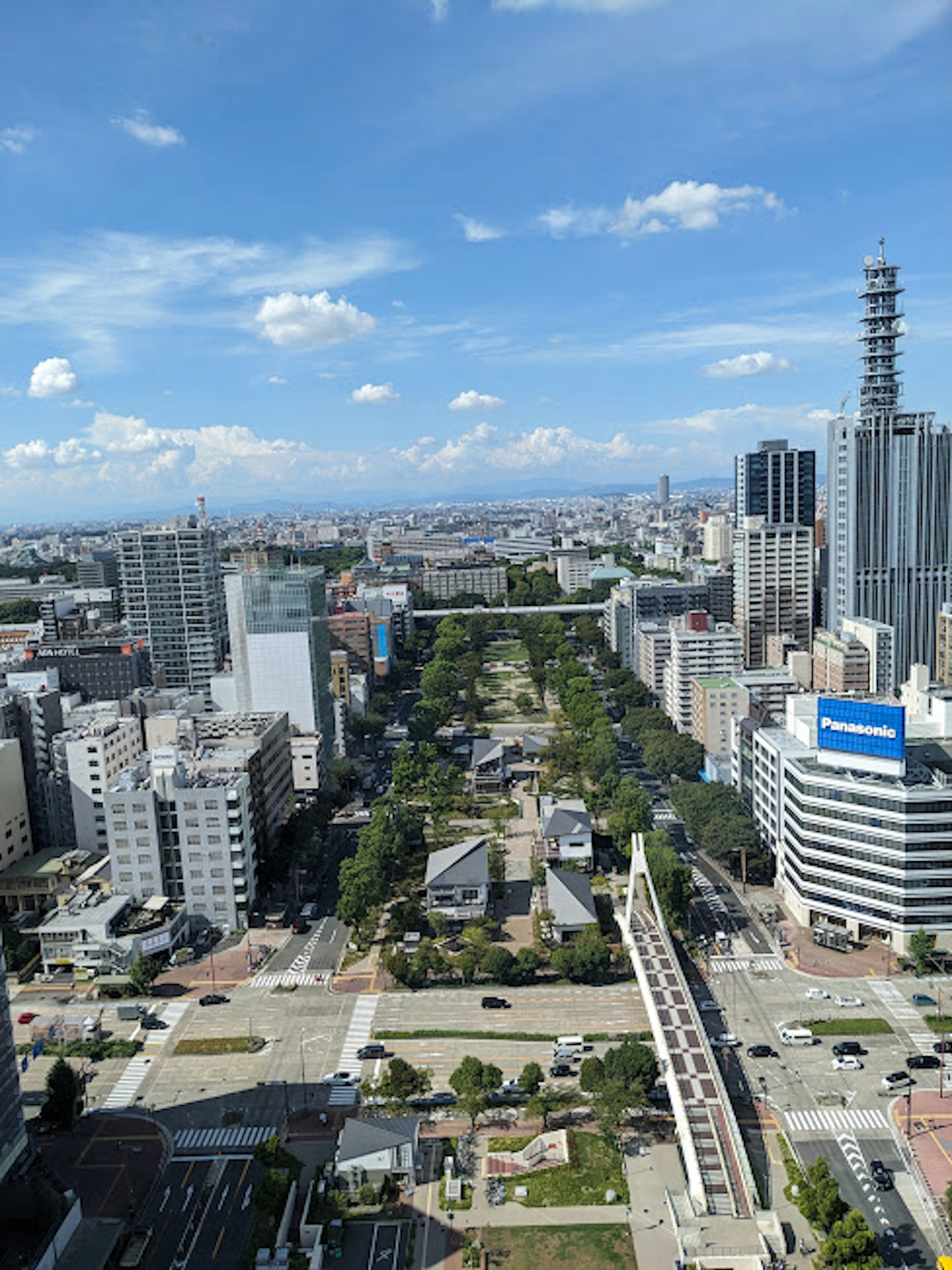 Vista aérea de un paisaje urbano con parques verdes y cielo azul