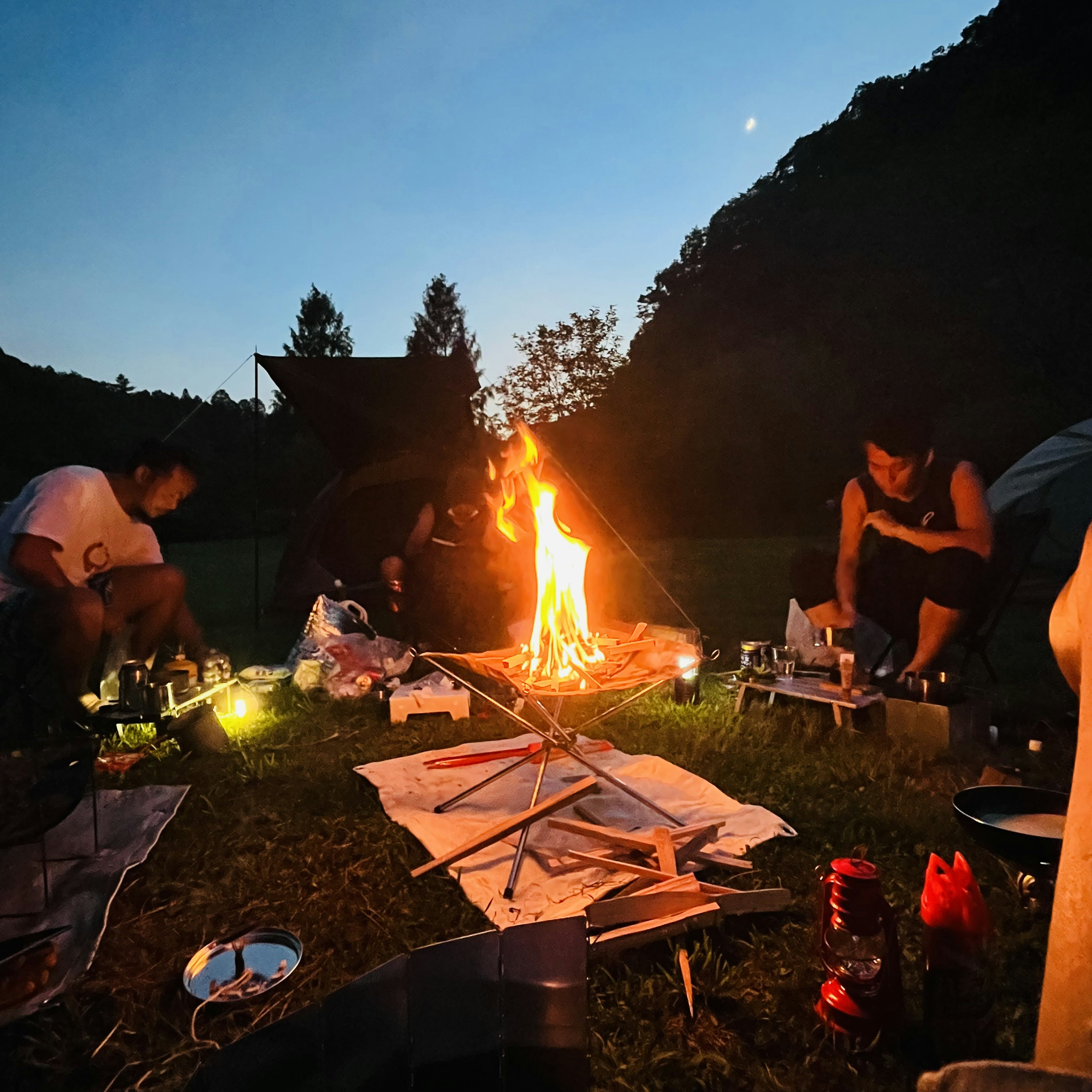 キャンプファイヤーを囲む人々と自然の風景