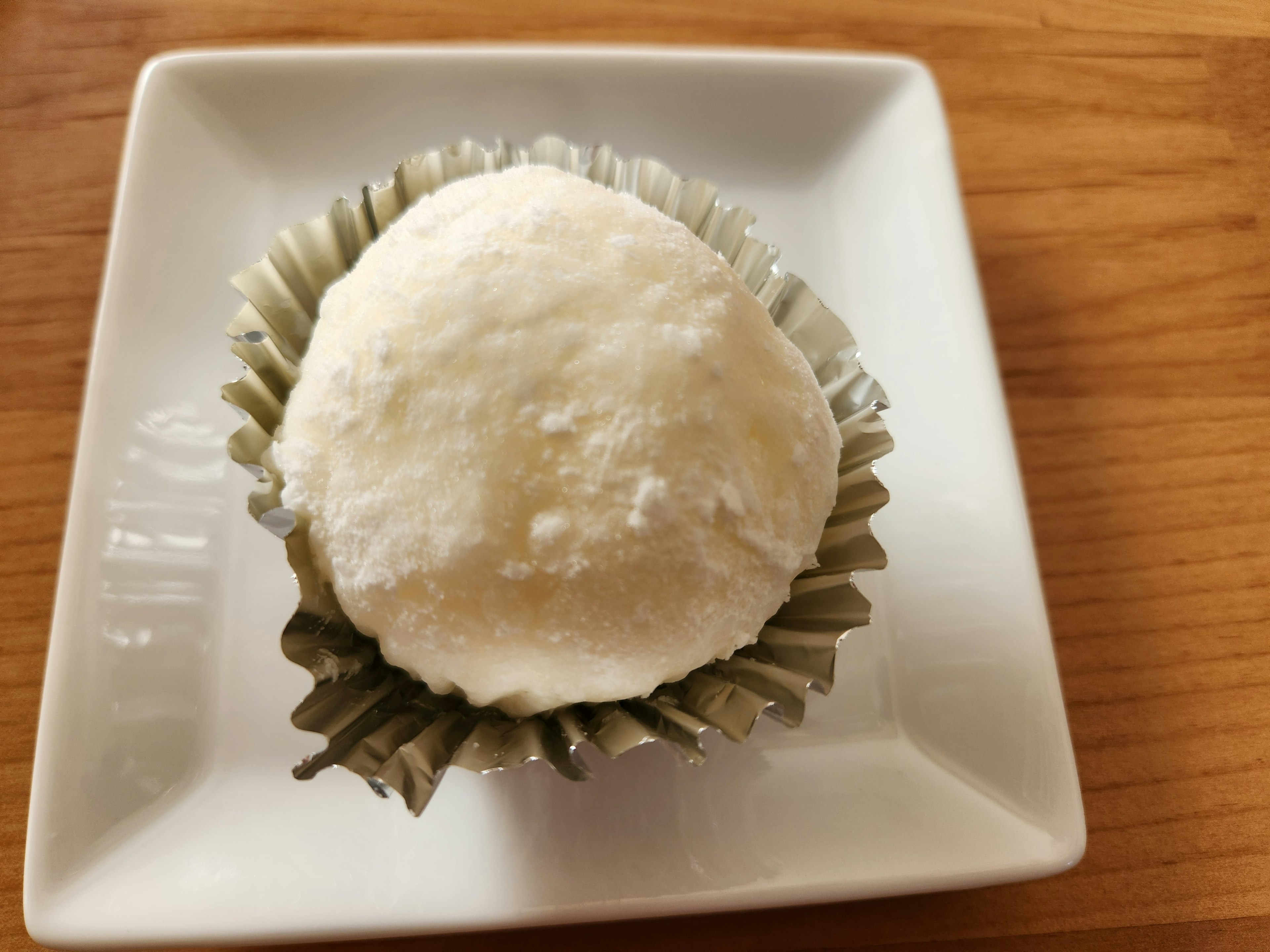 Ein weißes japanisches Dessert auf einem kleinen quadratischen Teller