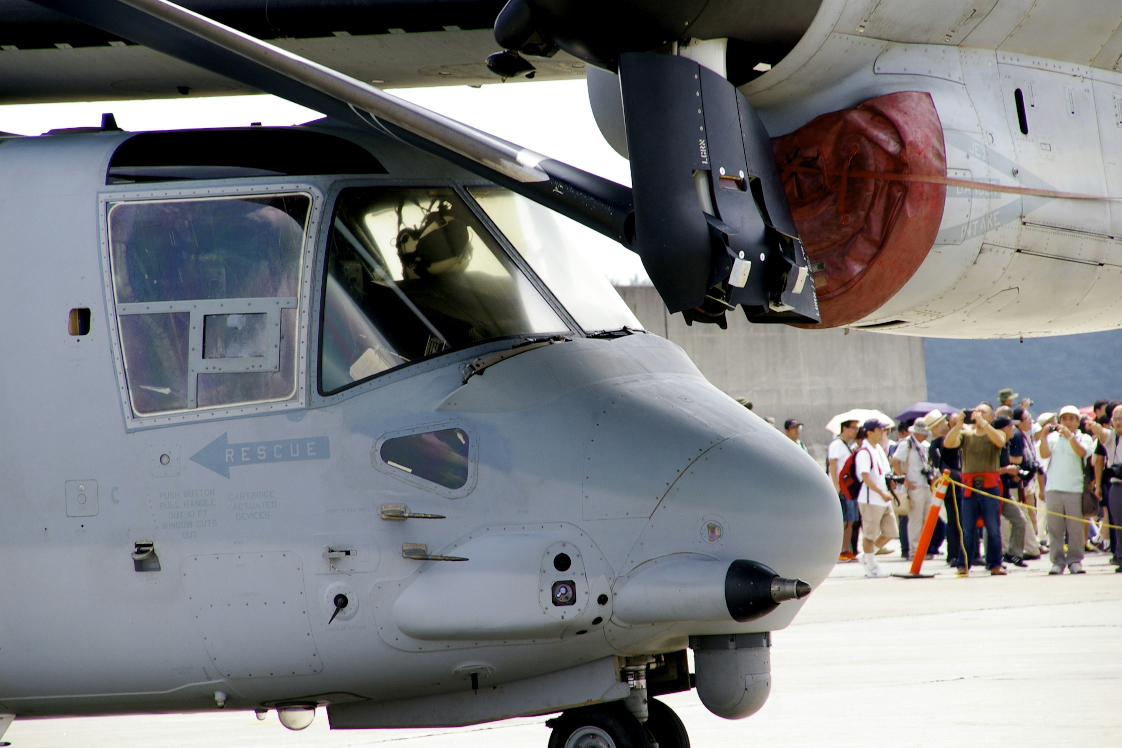 Cockpit di un elicottero con persone sullo sfondo a un airshow