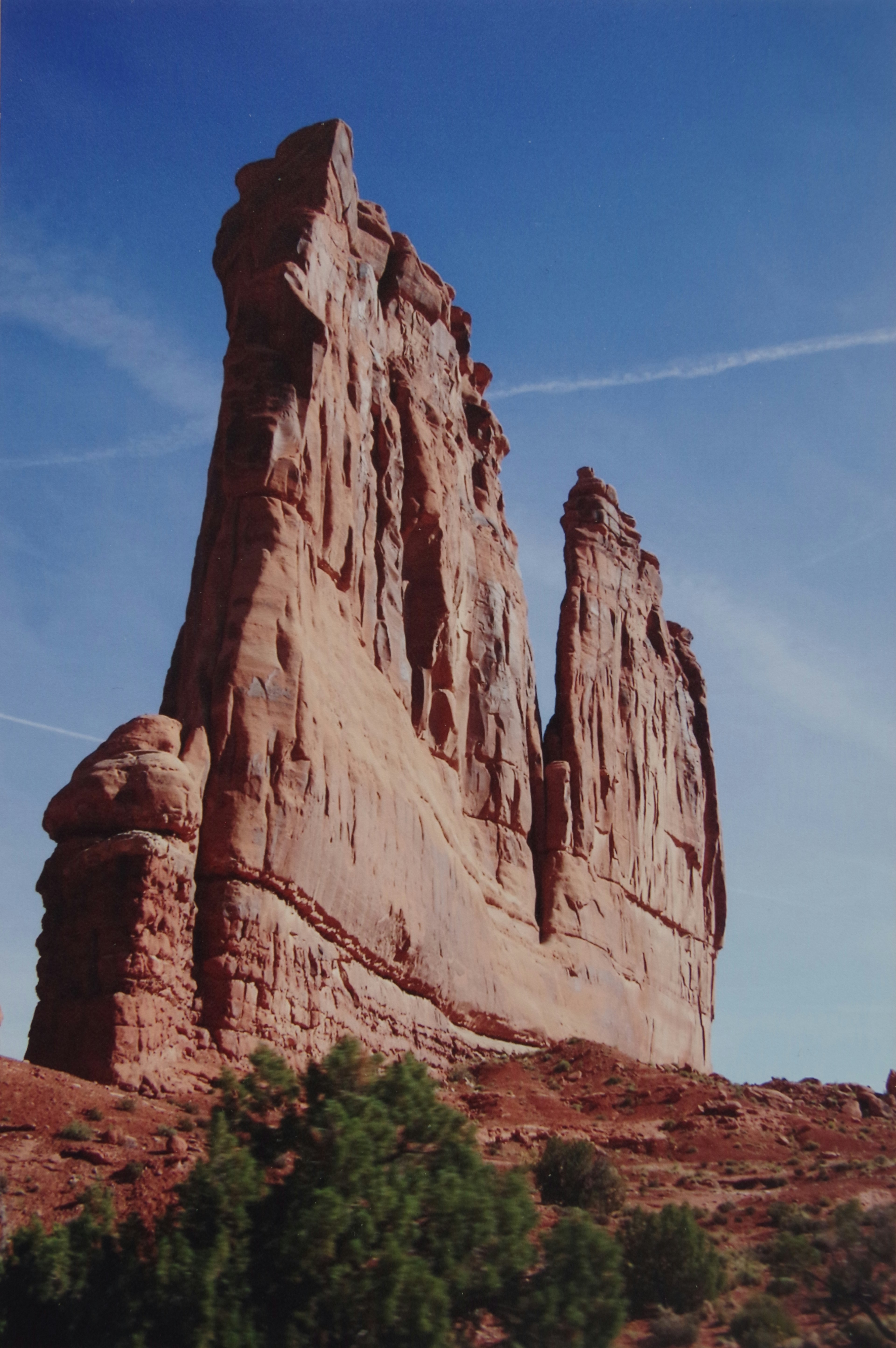 Tall red rock formations rising against a clear blue sky