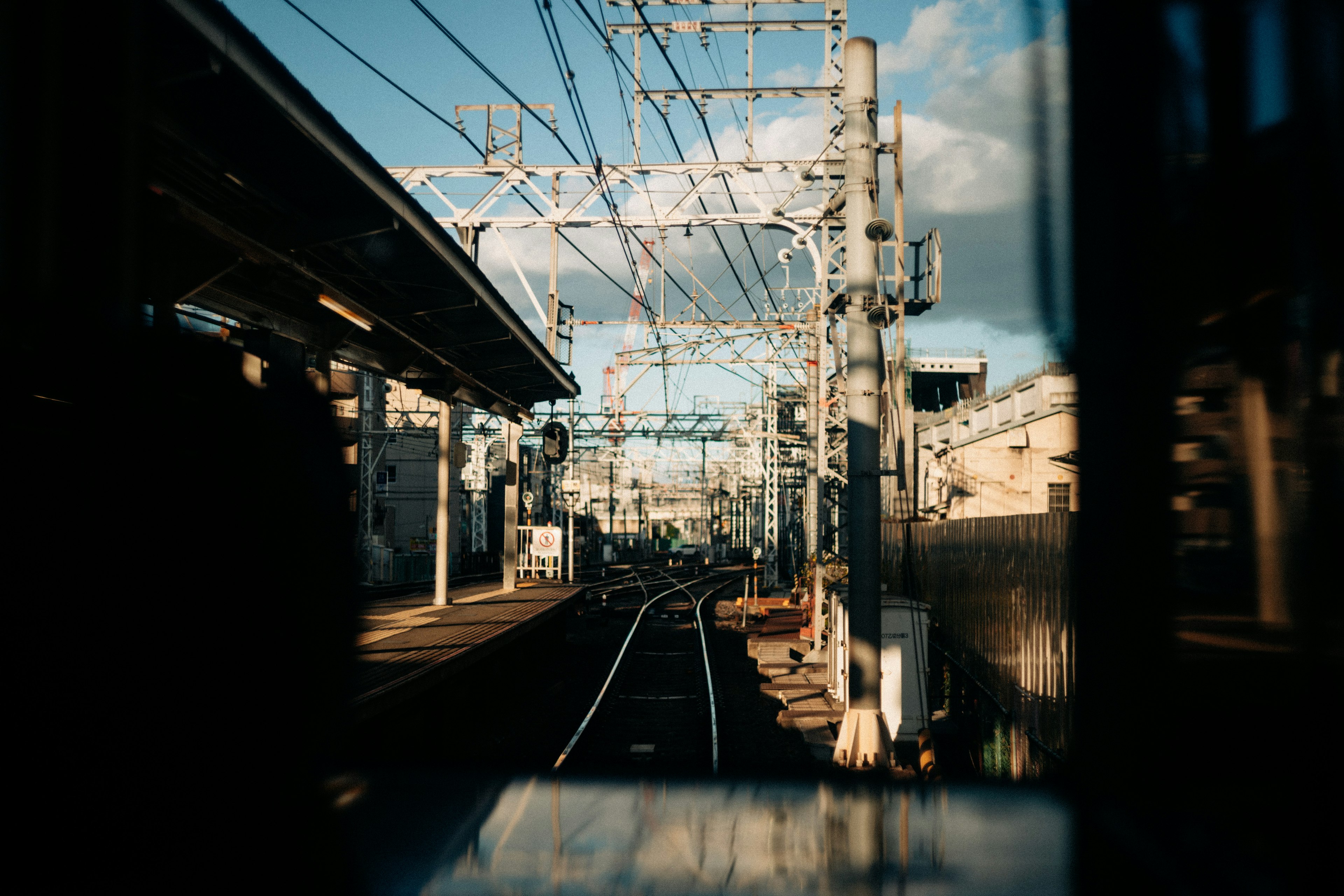 View from a train window showing tracks and a station