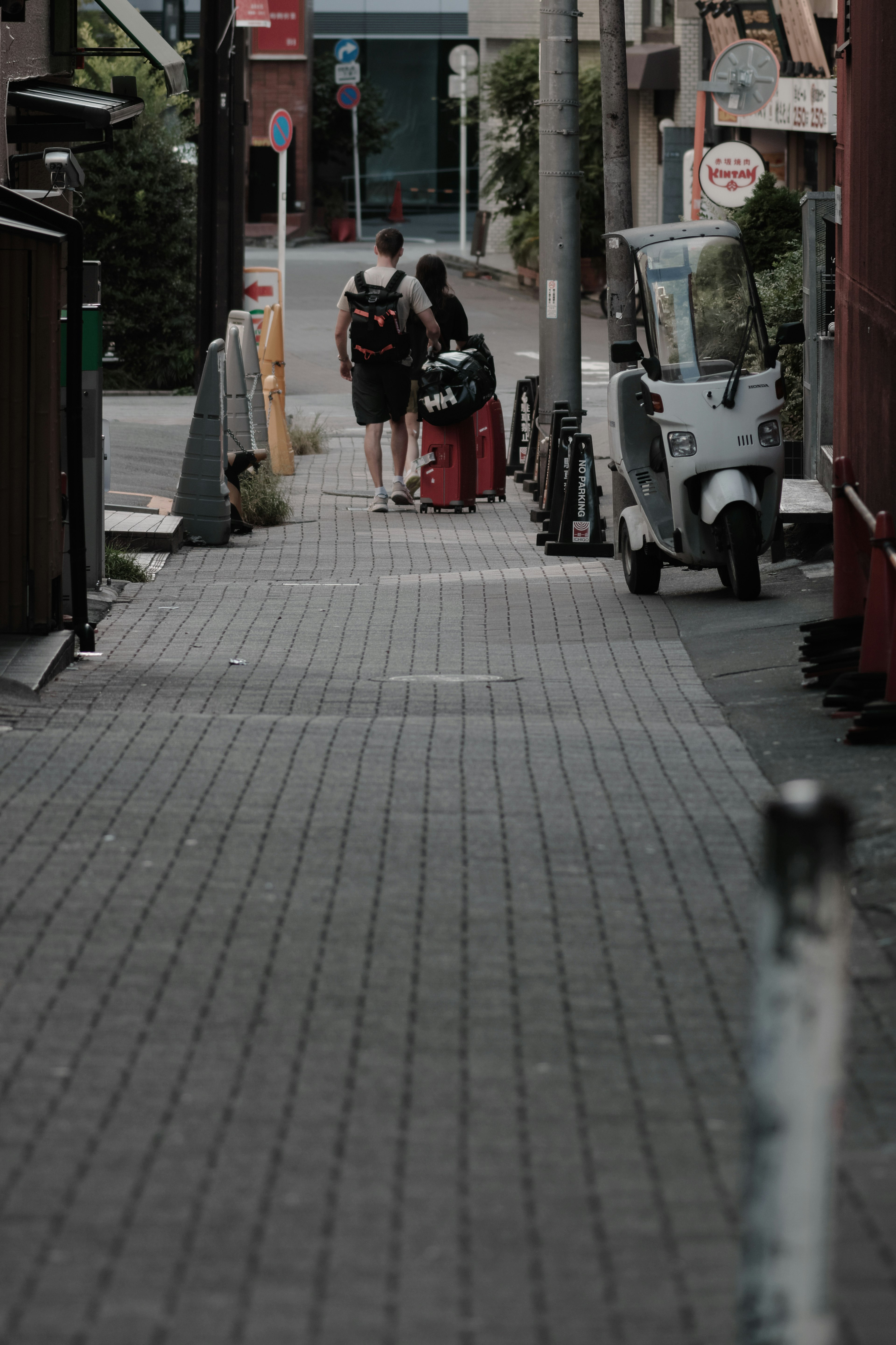 Couple walking in a quiet alley with a tricycle nearby