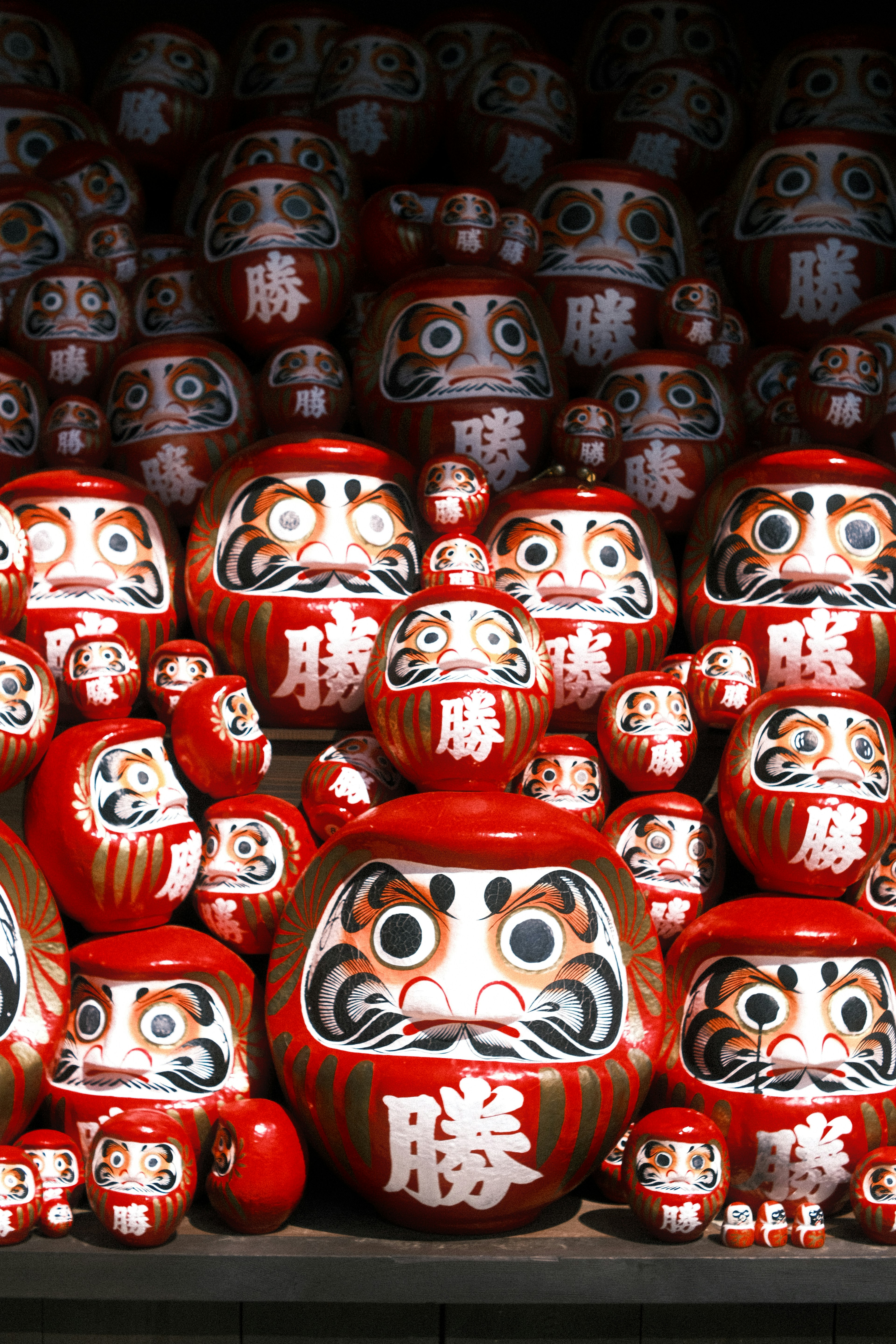 Numerous red daruma dolls arranged together