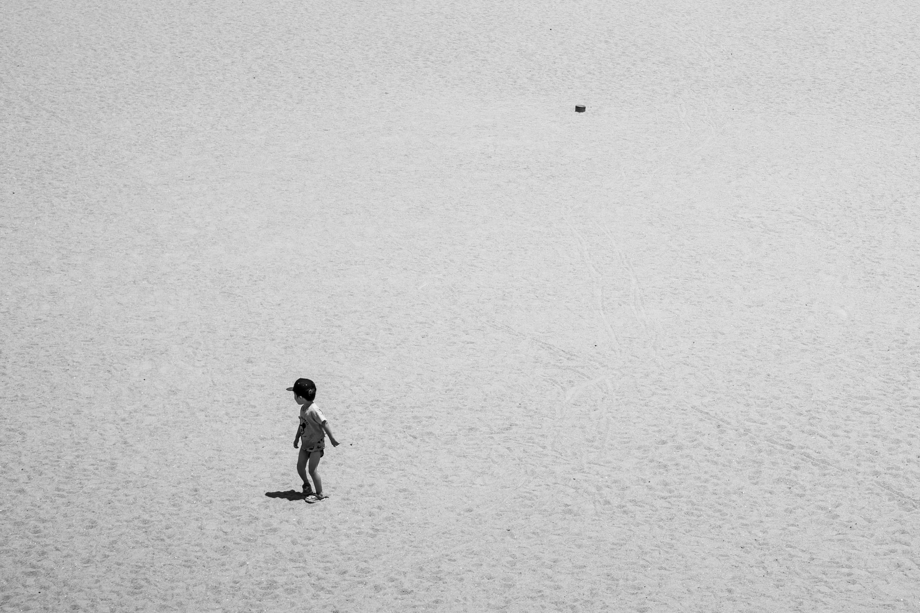 Silhouette d'un enfant marchant dans un désert en noir et blanc