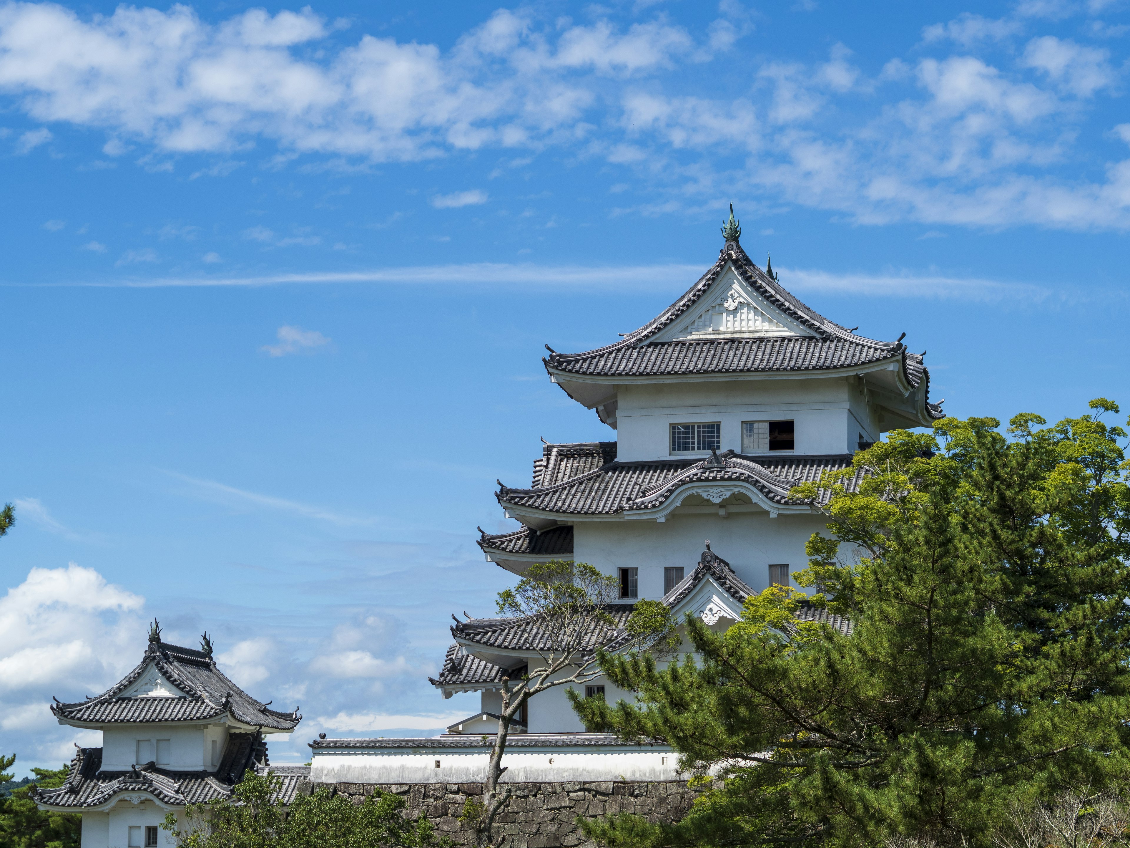 Beautiful white castle tower under blue sky with green trees