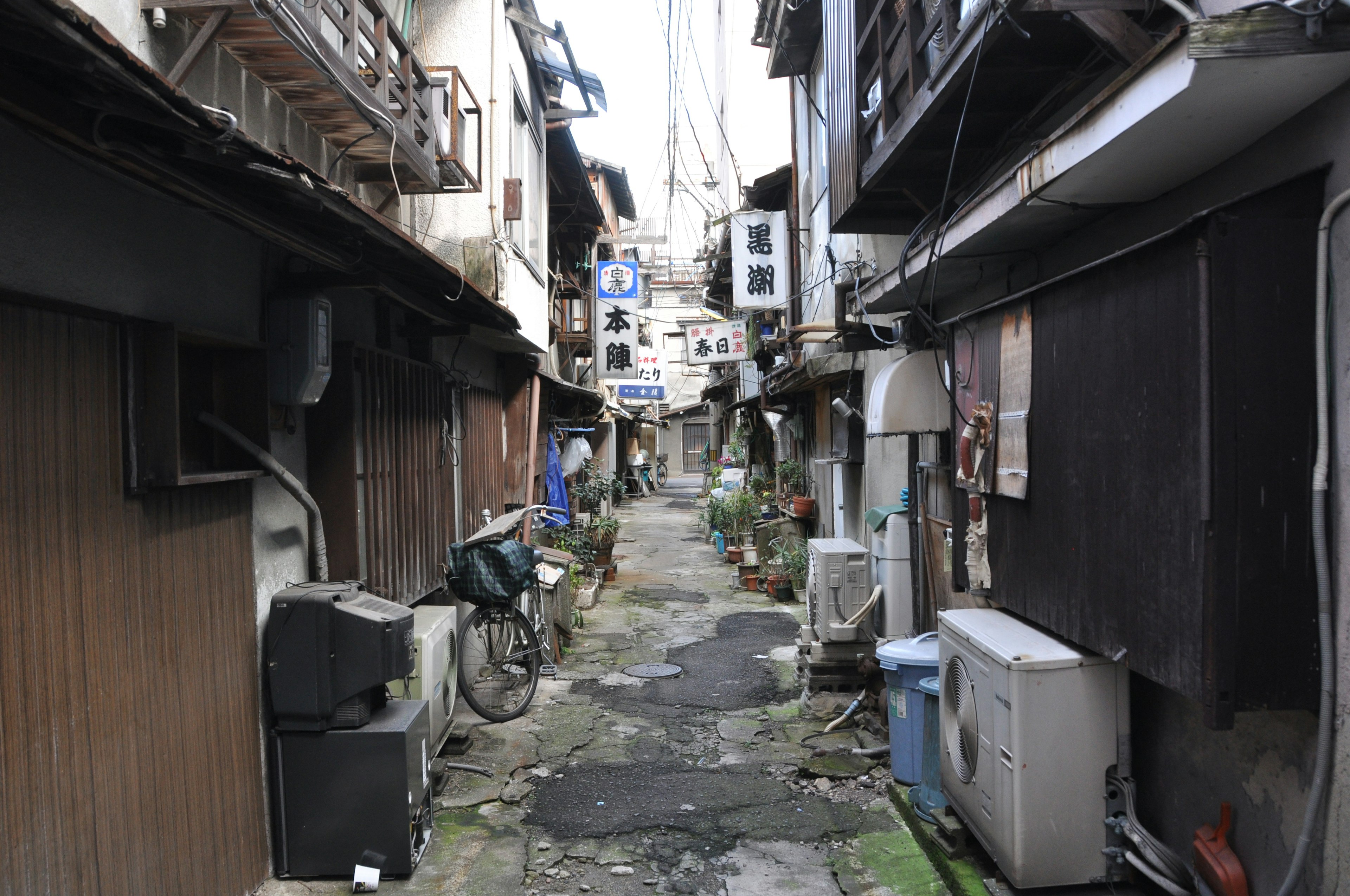 Narrow alley lined with old buildings and signs of daily life