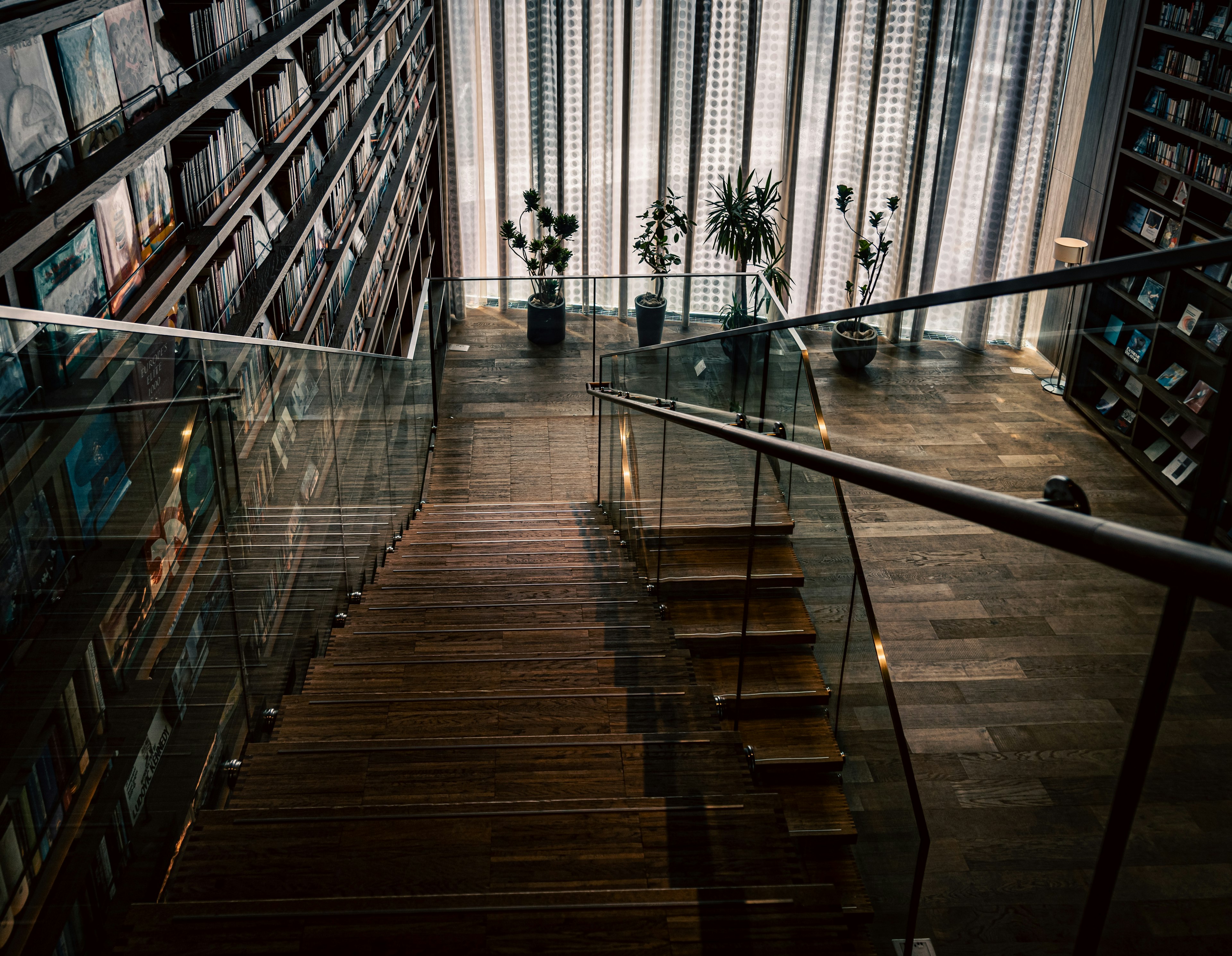 Vista interna di una biblioteca moderna con scale e scaffali