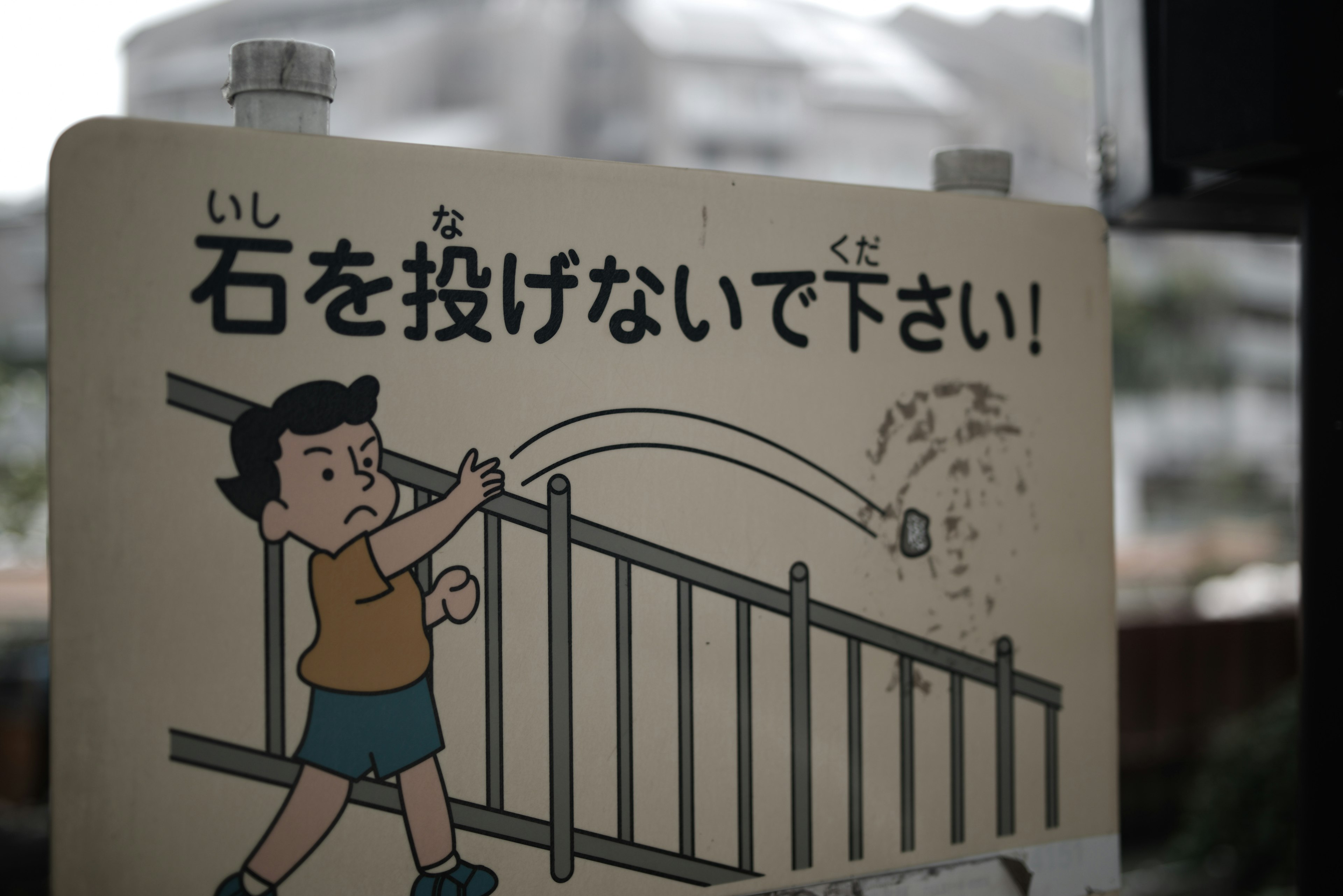 Sign warning against throwing stones with a cartoon child