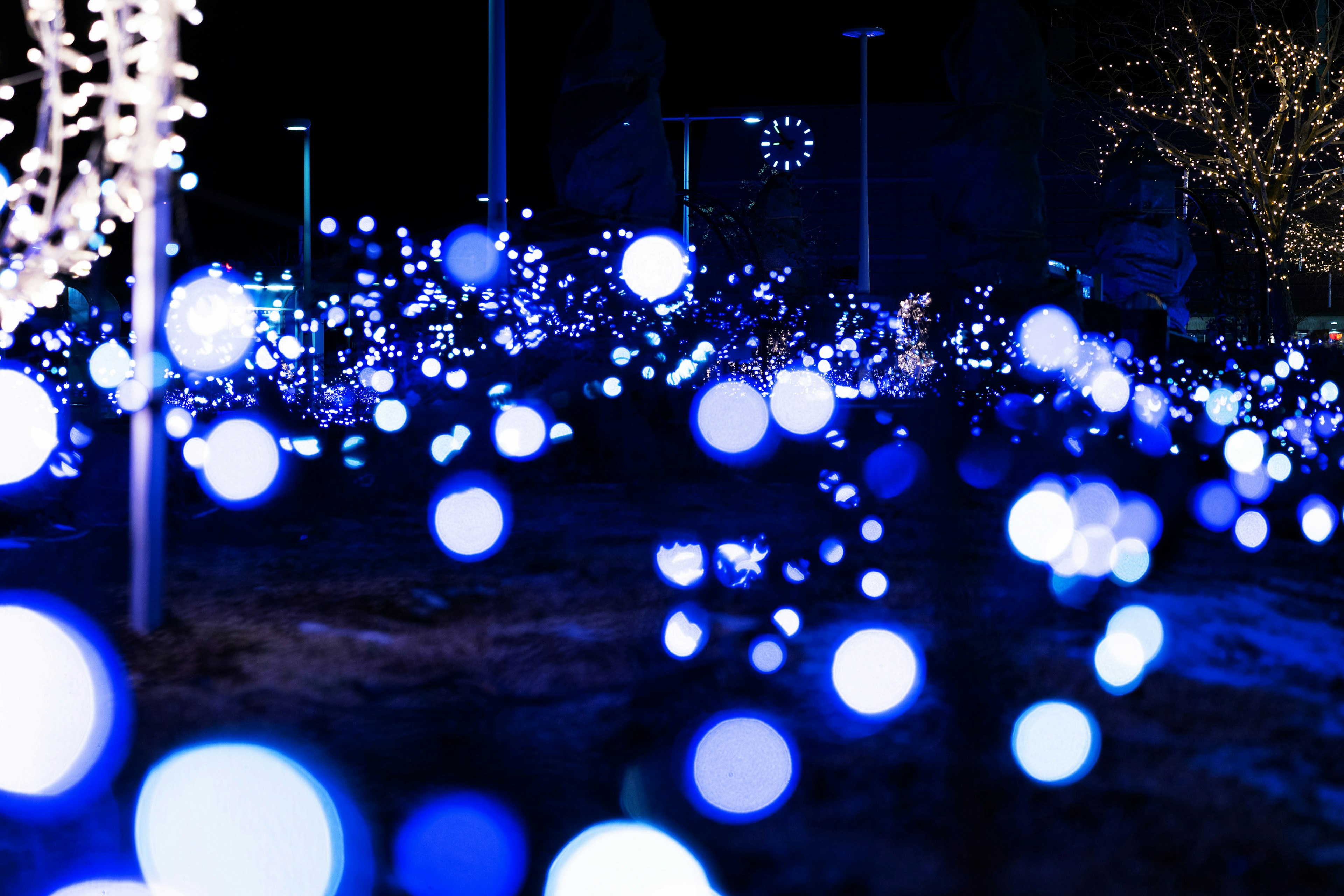 青い光の球体が広がる夜の風景