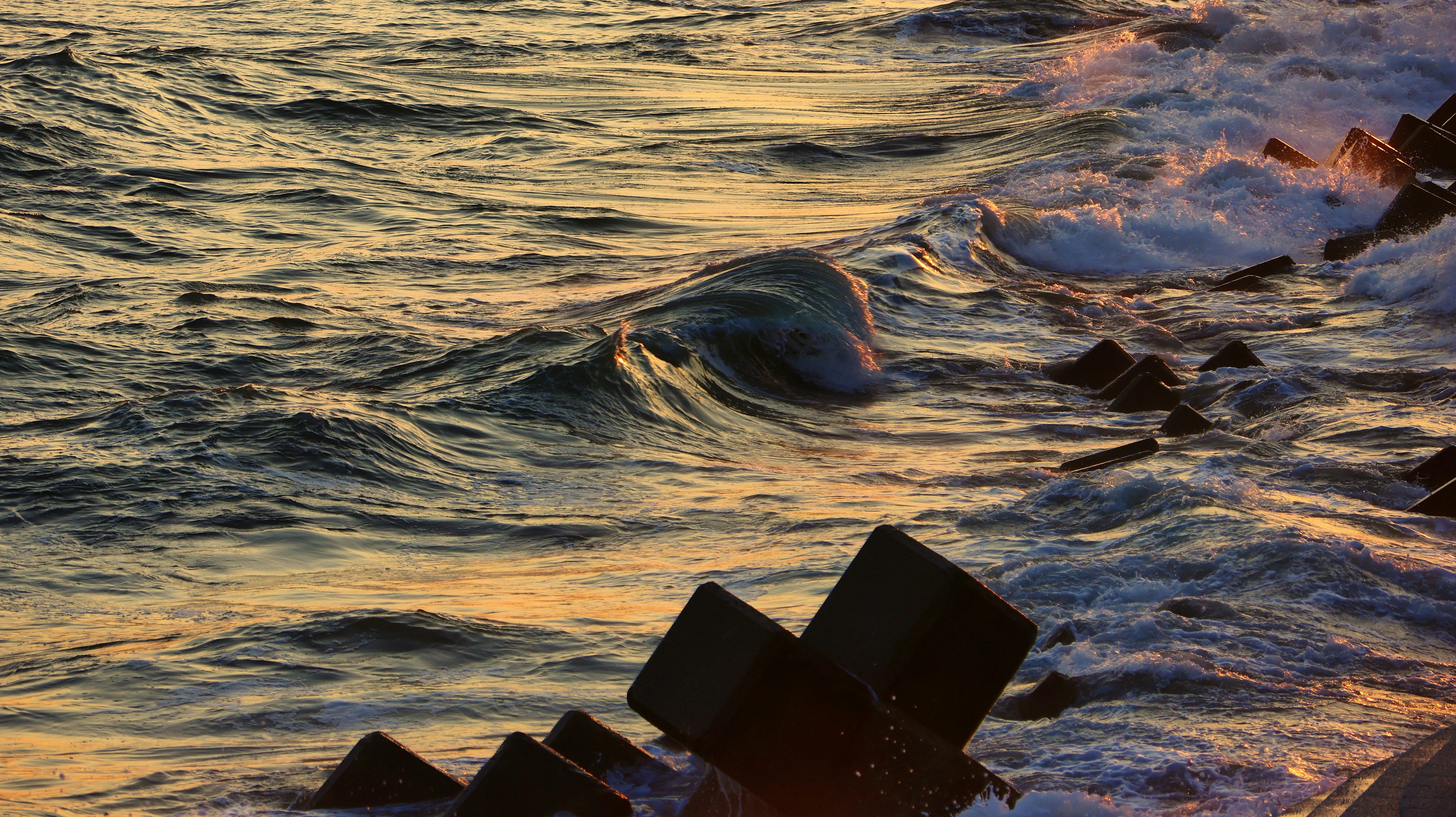 Waves crashing on the shore at sunset