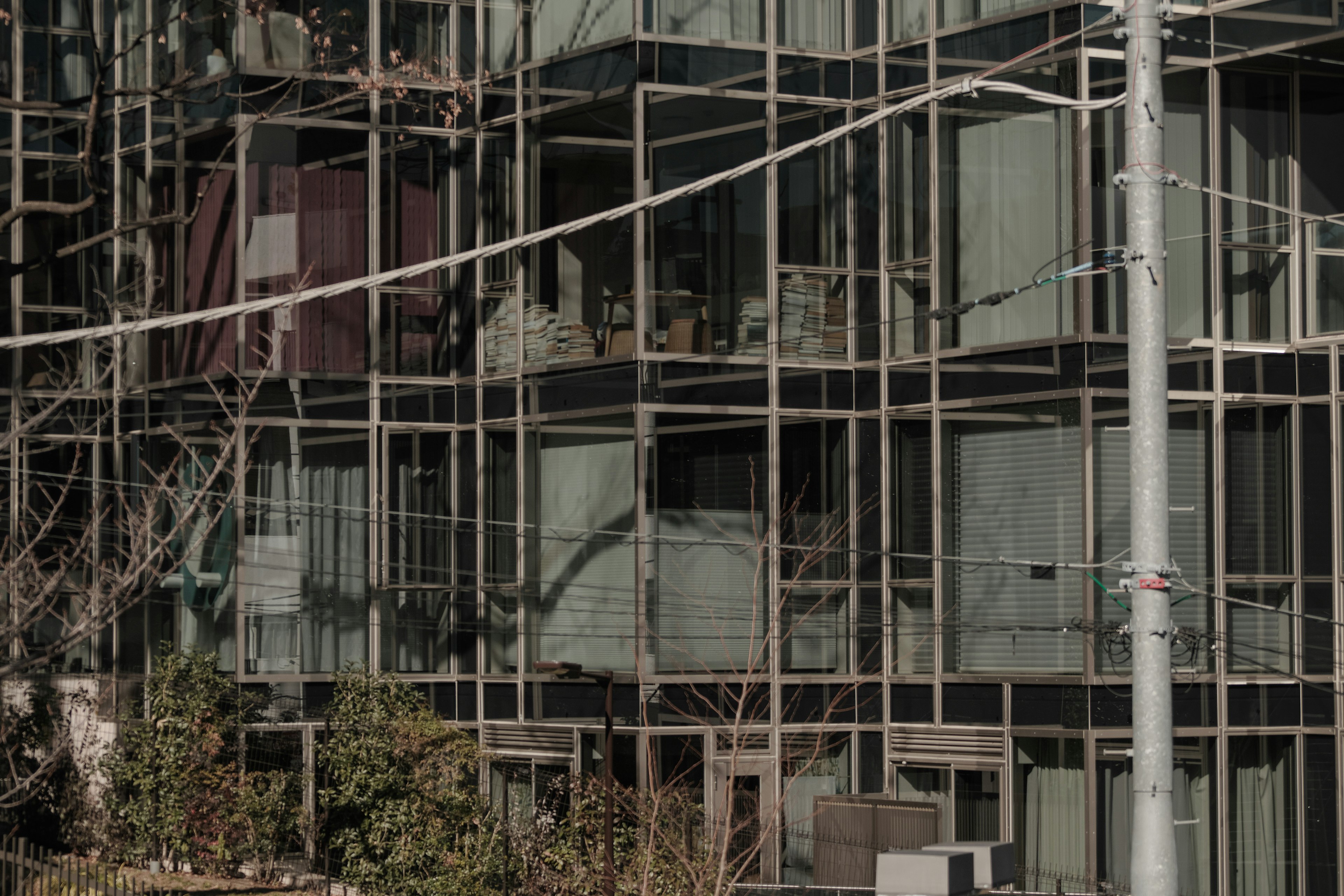 Exterior de un edificio moderno con estructura de vidrio y metal algunas áreas inacabadas con andamios visibles