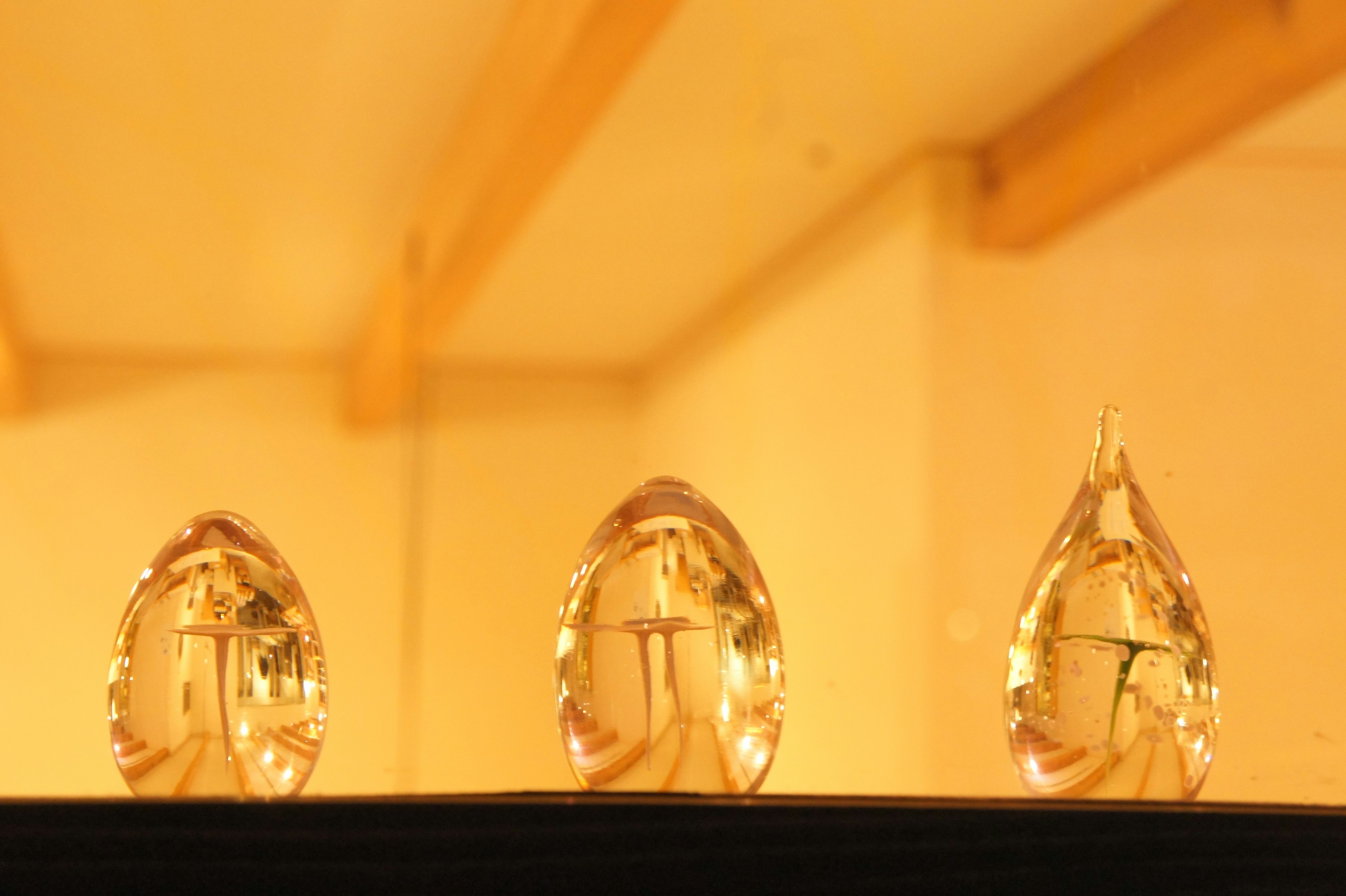 Three crystal objects arranged in a row with warm lighting