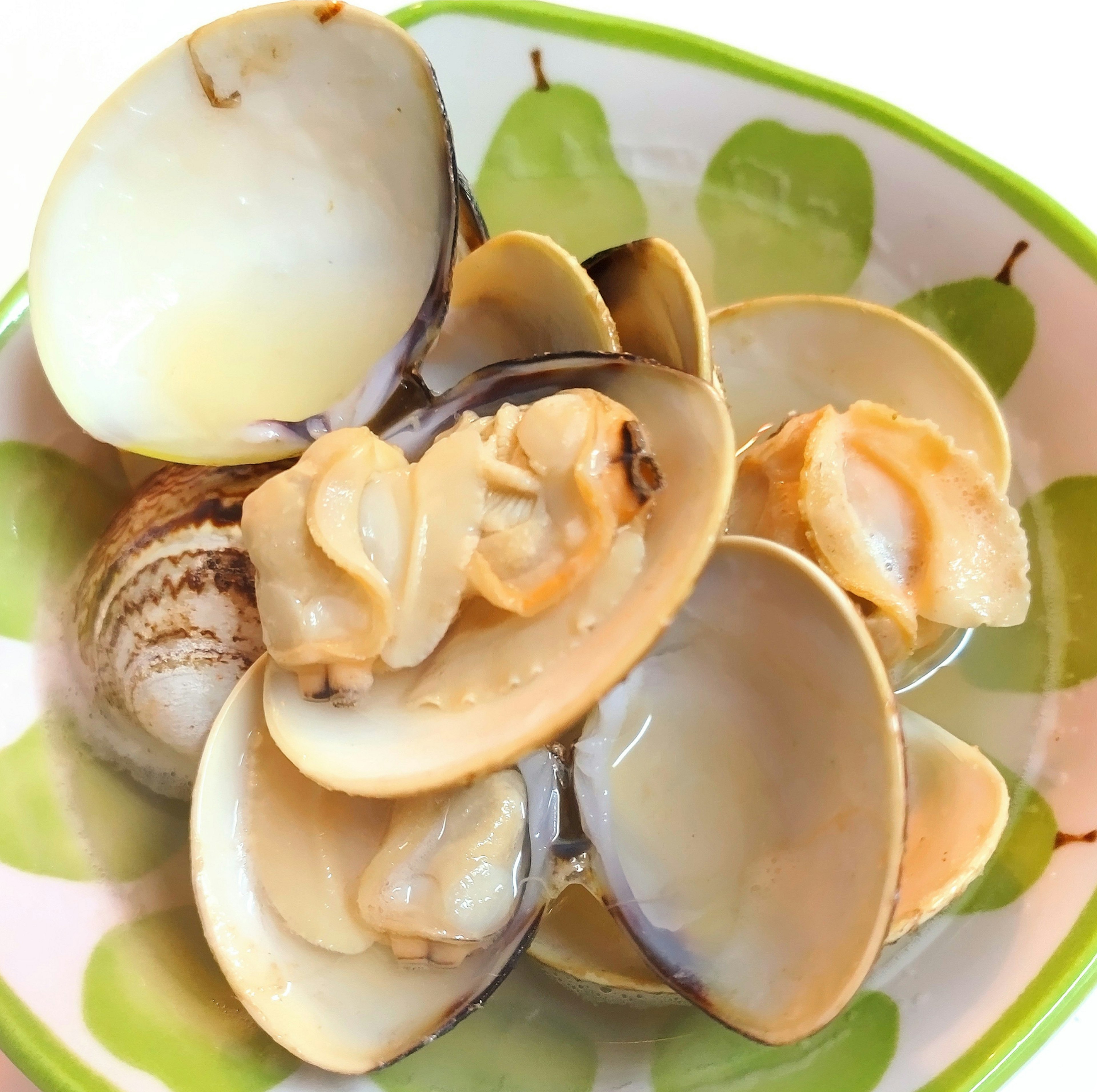 A plate with a cluster of fresh clams arranged on it