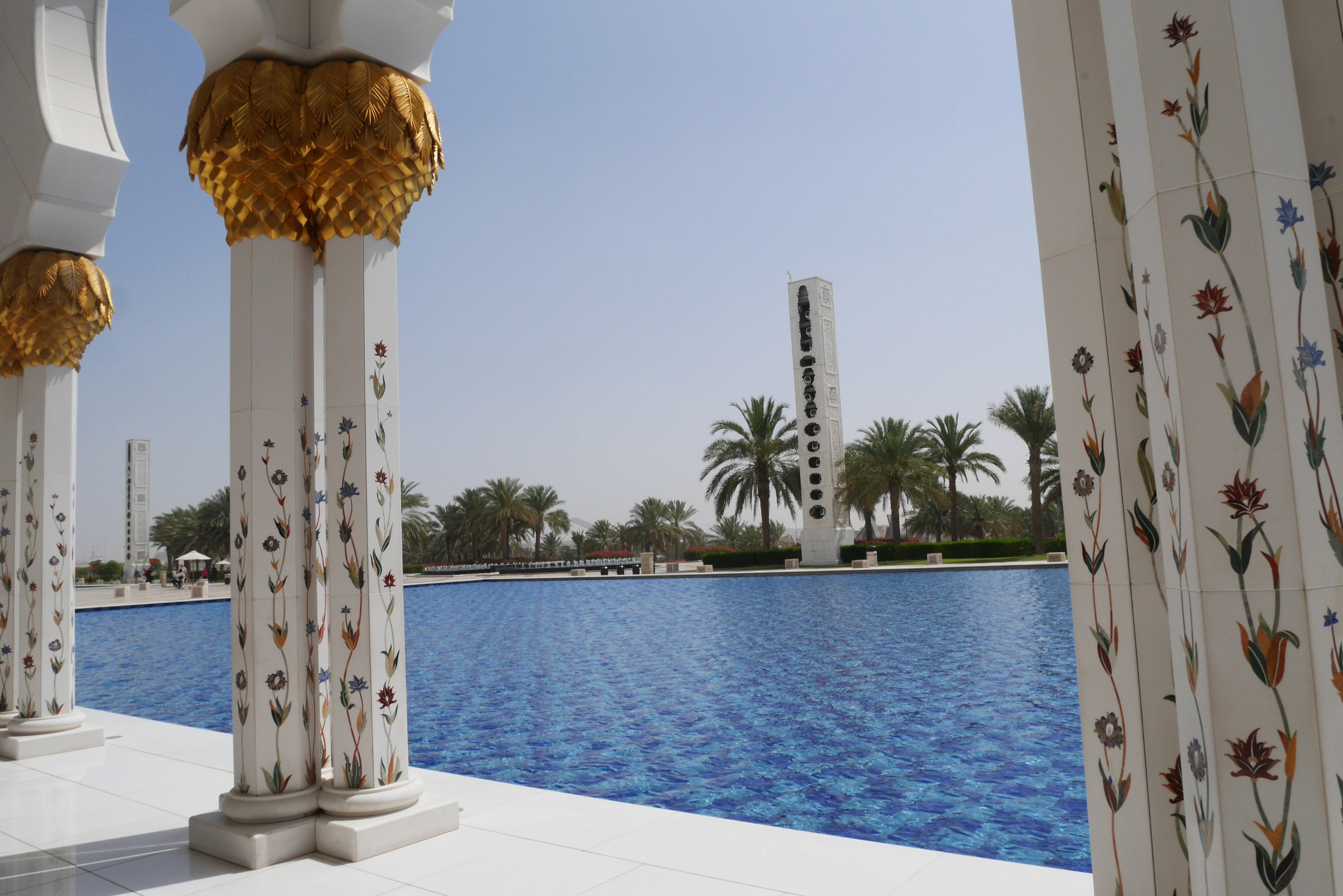 Vista di un giardino con una piscina blu e colonne decorative