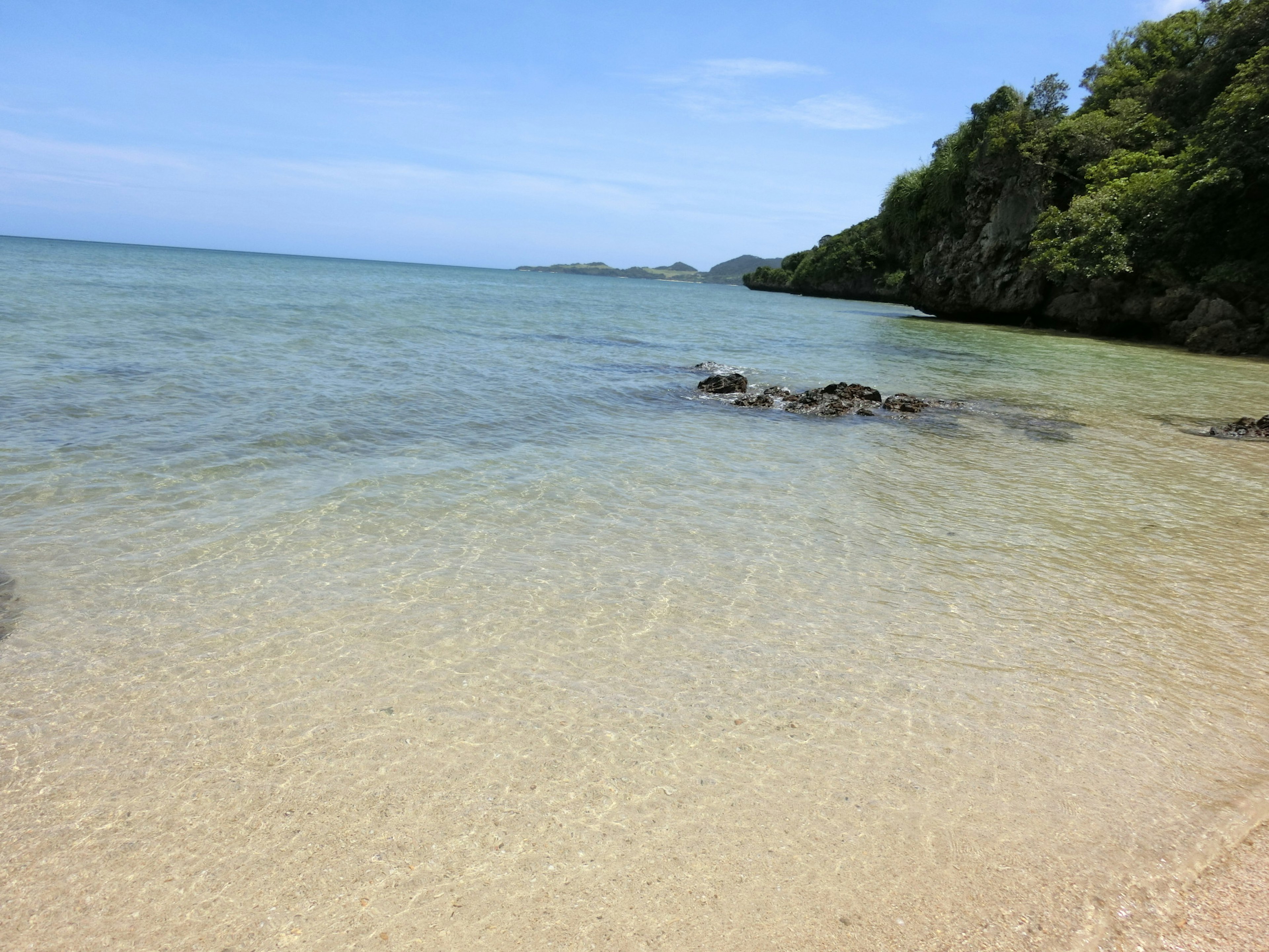 Pemandangan pantai yang indah dengan laut biru dan tepi pasir jernih