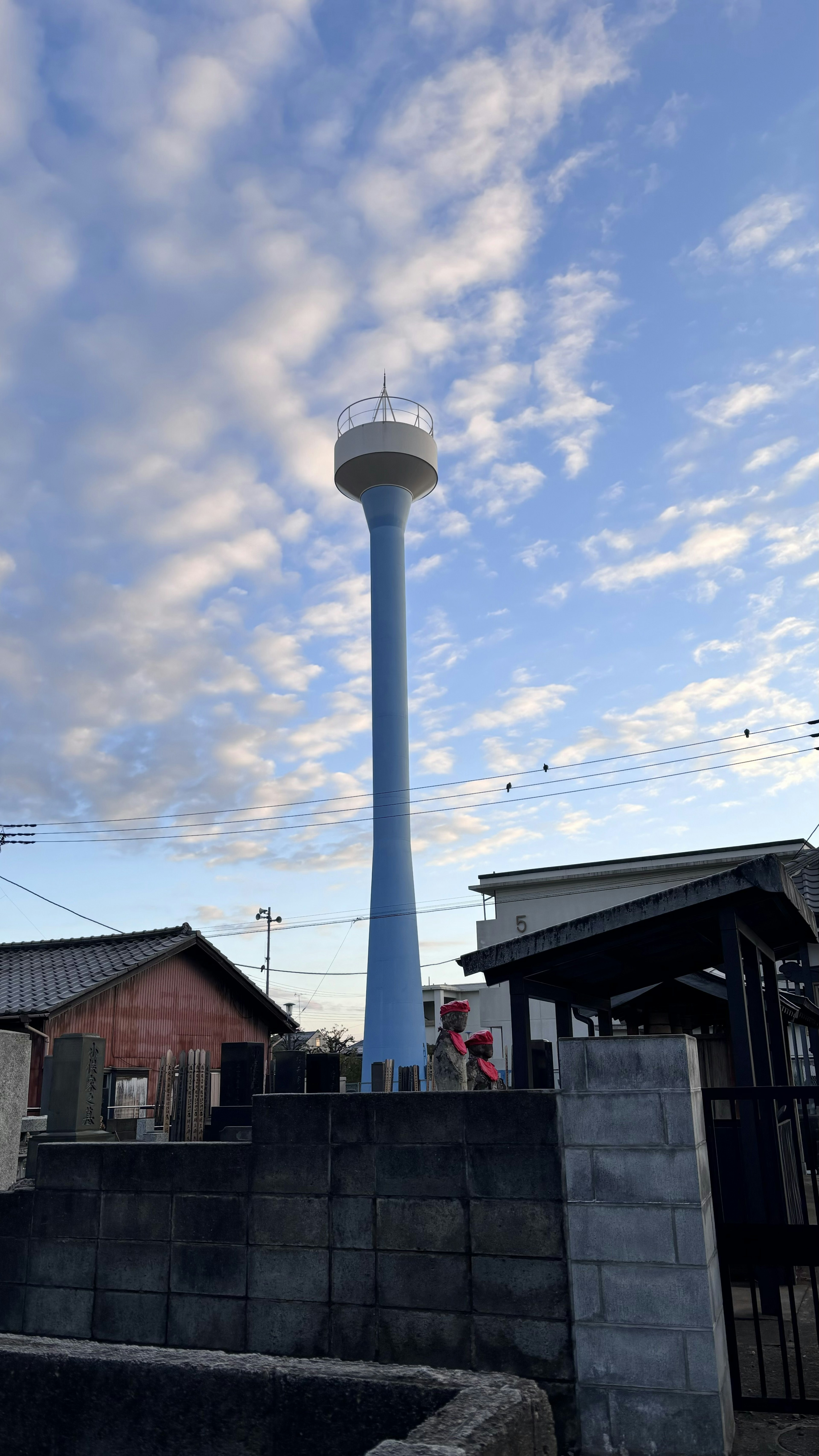 Un réservoir d'eau bleu se dresse contre un ciel bleu avec des nuages