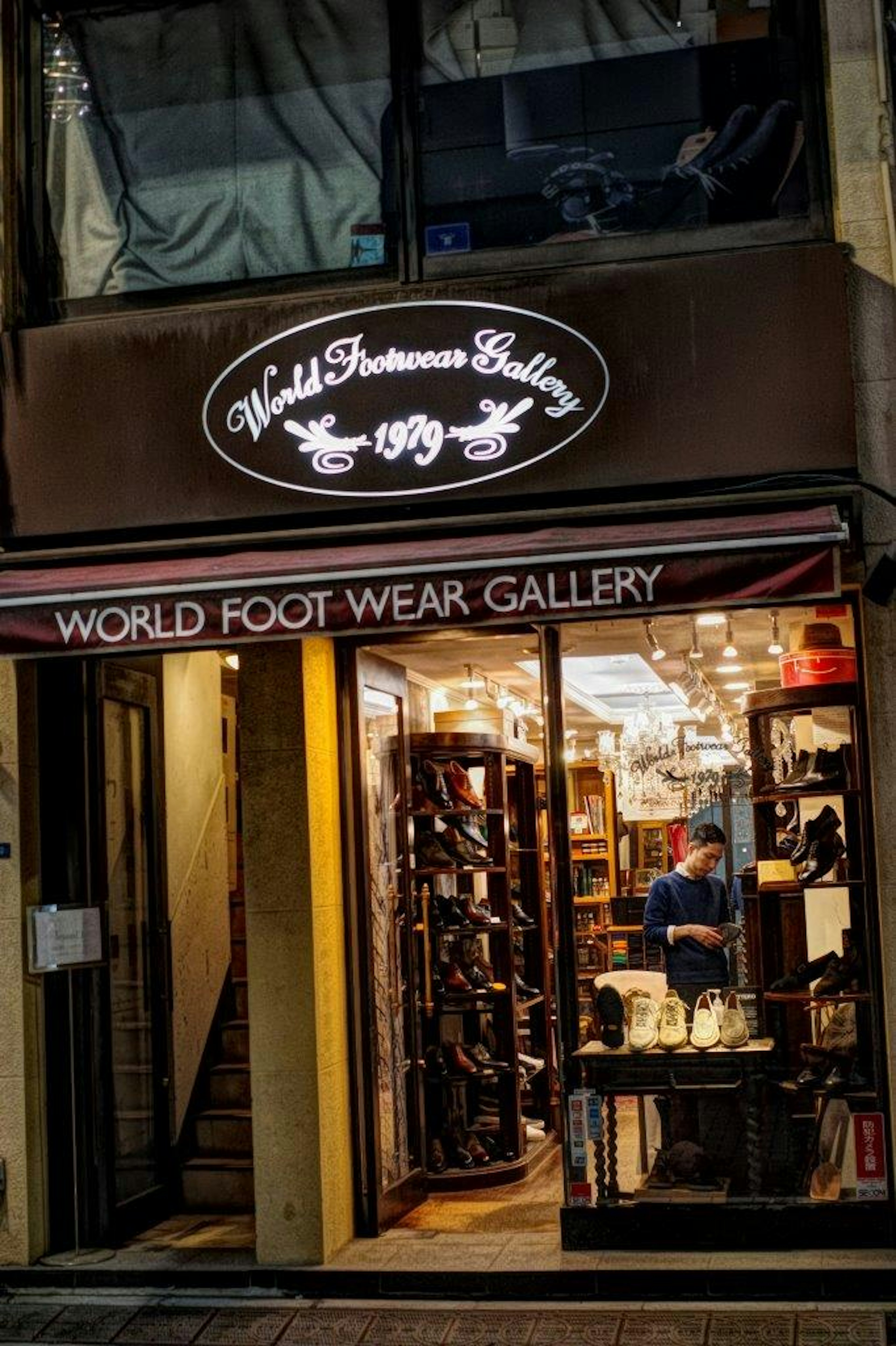 Exterior de una galería de calzado con iluminación brillante y una variedad de zapatos