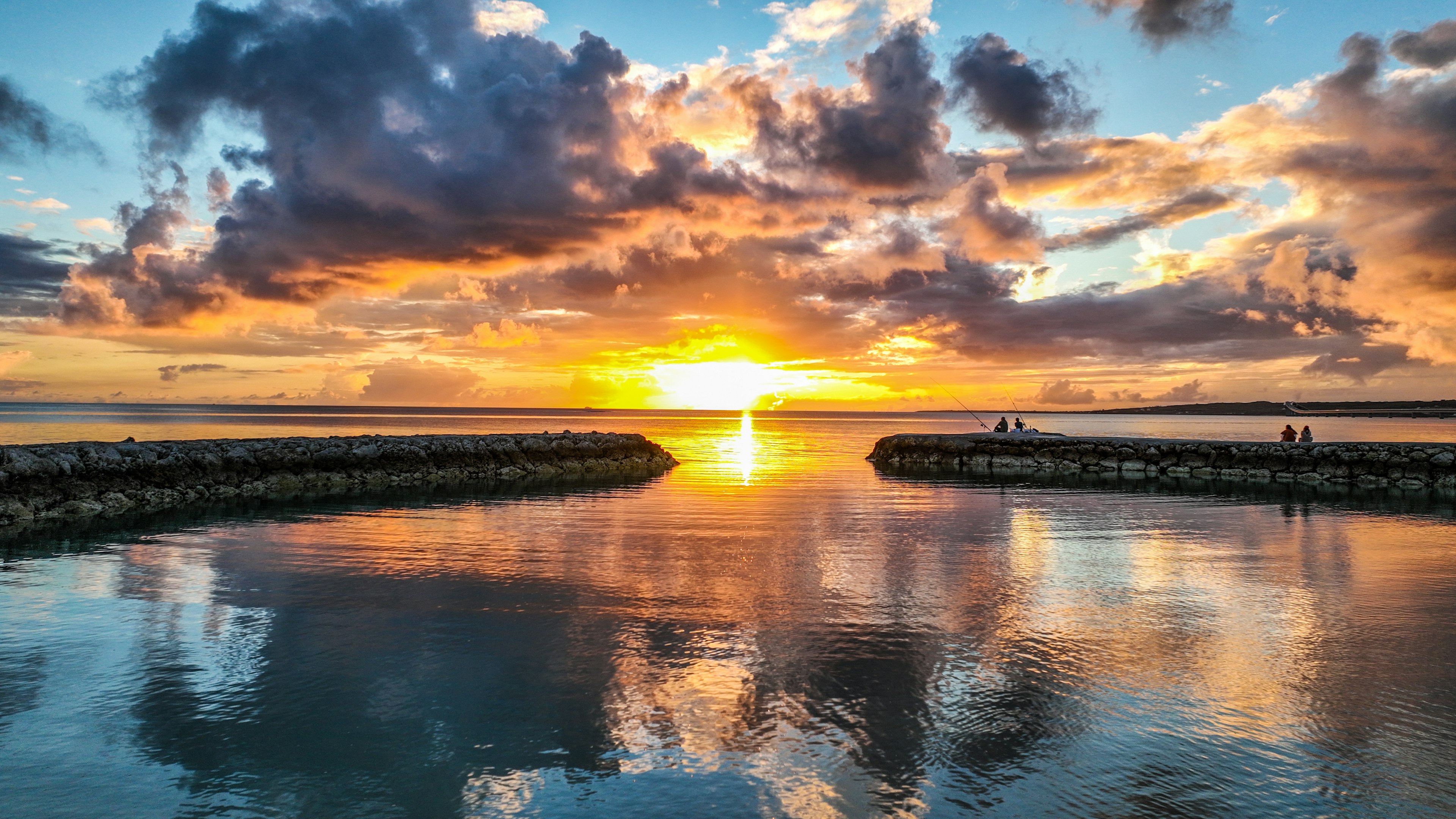 Sonnenuntergang über einem ruhigen Meer mit bunten Wolken, die sich im Wasser spiegeln