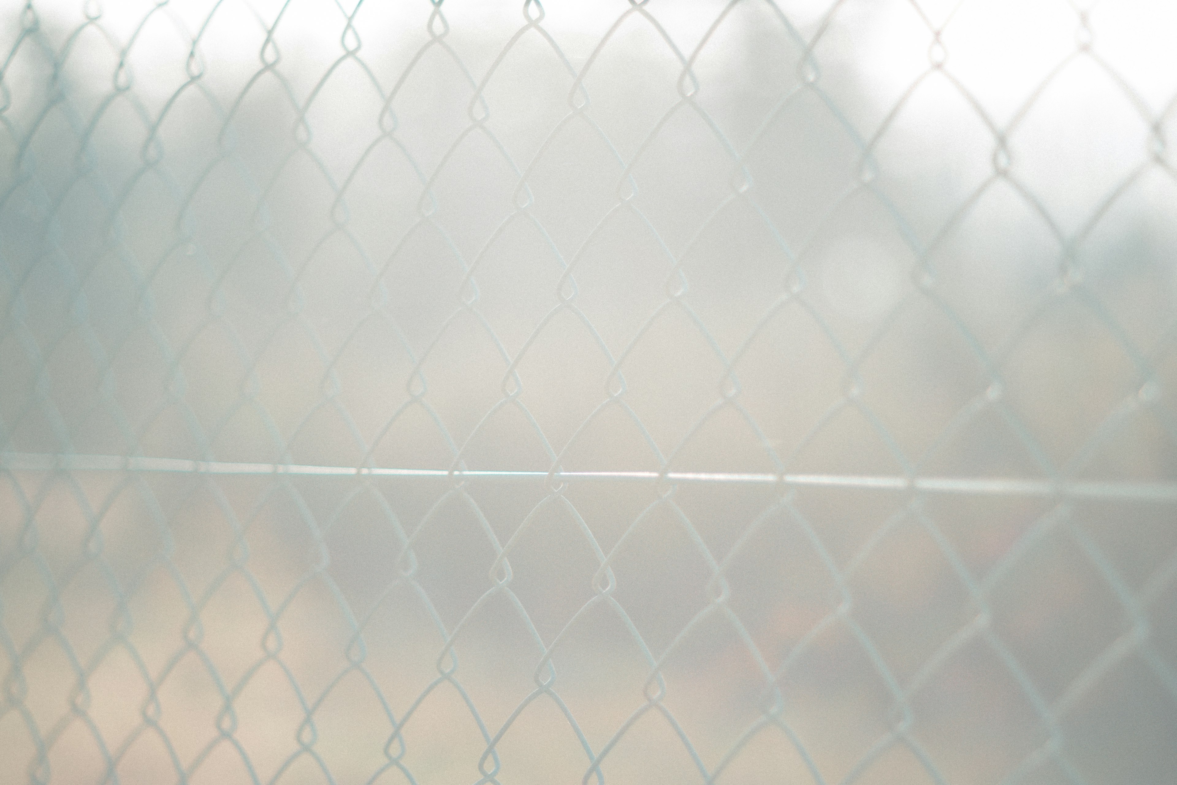 Image of a blurred background featuring a metallic fence