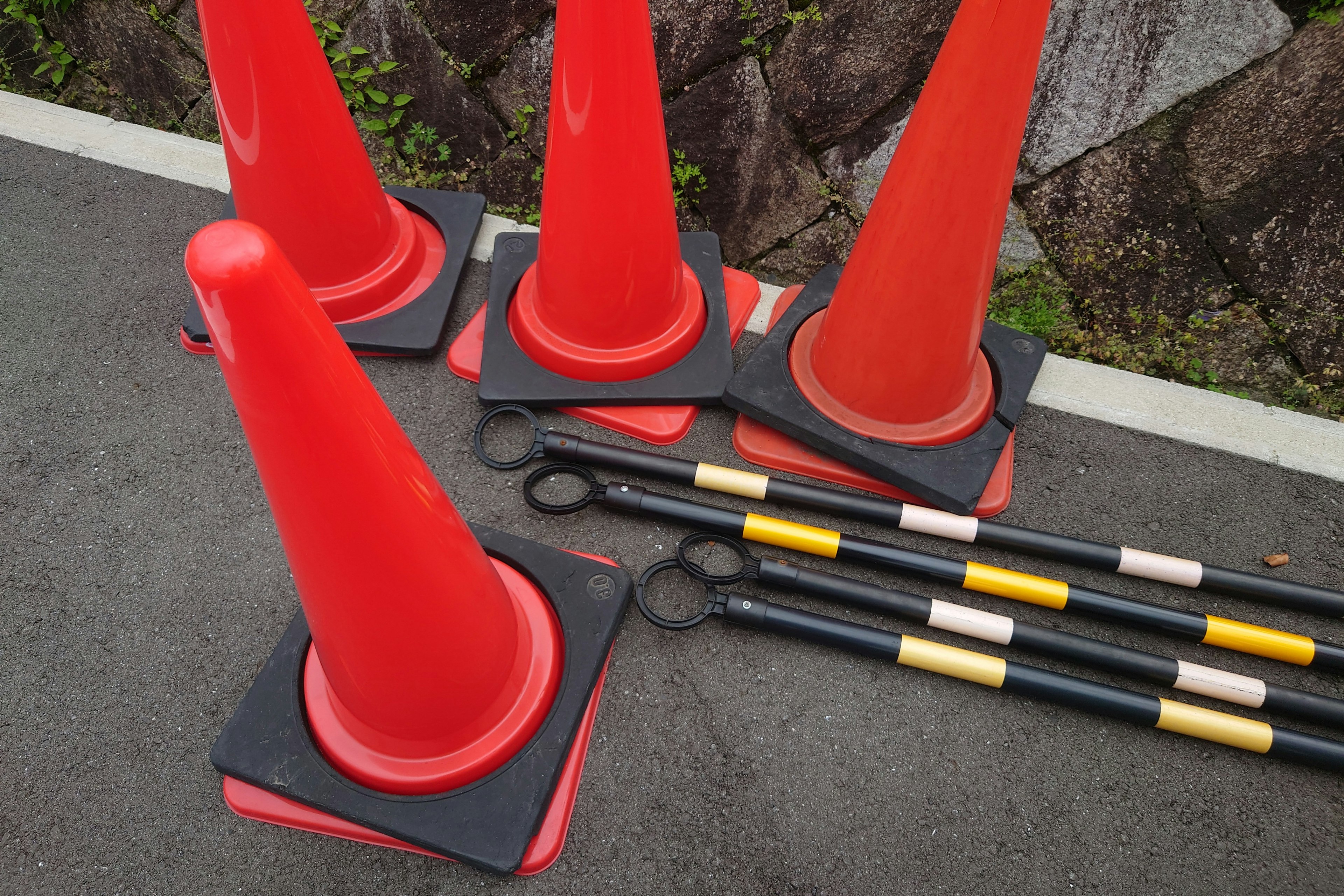 Red traffic cones and black rods are arranged together