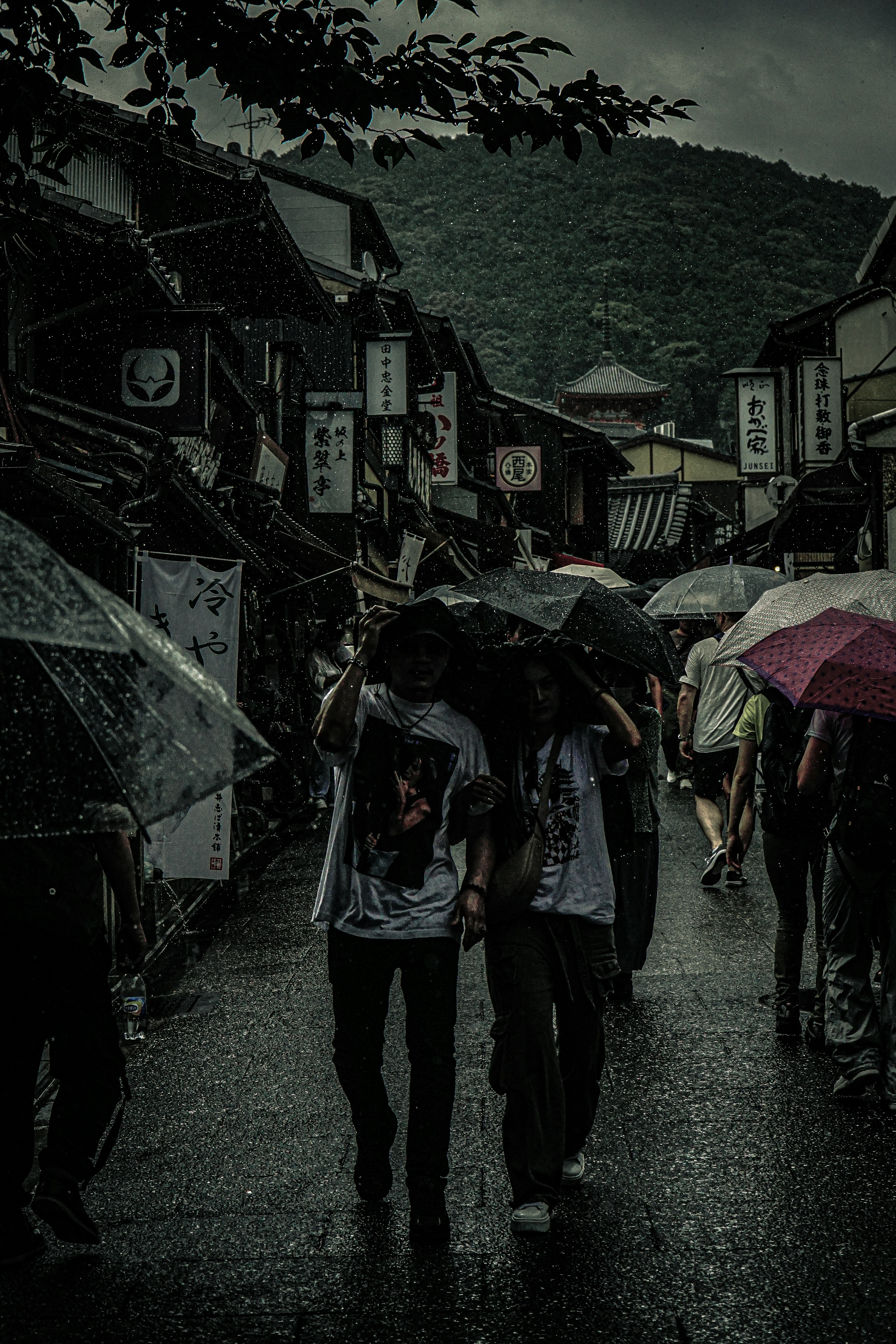 人在雨中撑伞走在历史街道上的场景