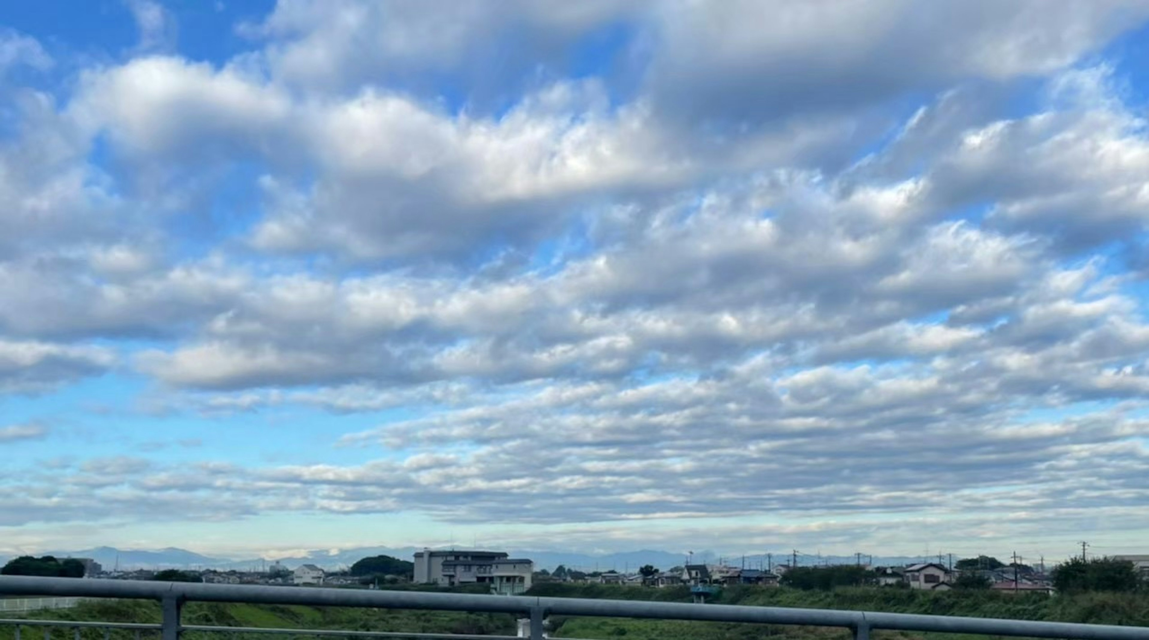 青空と雲が広がる風景と住宅