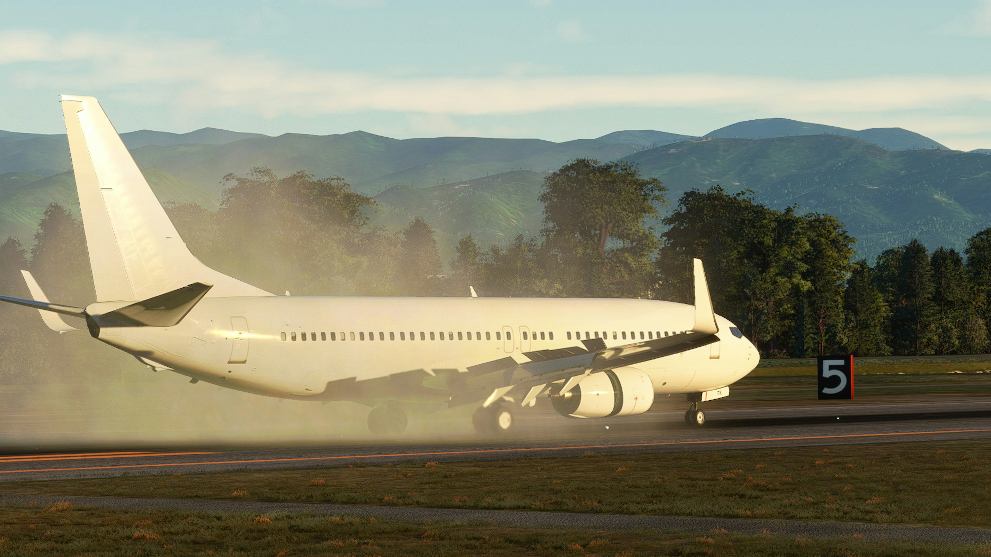 White passenger airplane landing on runway with dust clouds and mountains in the background