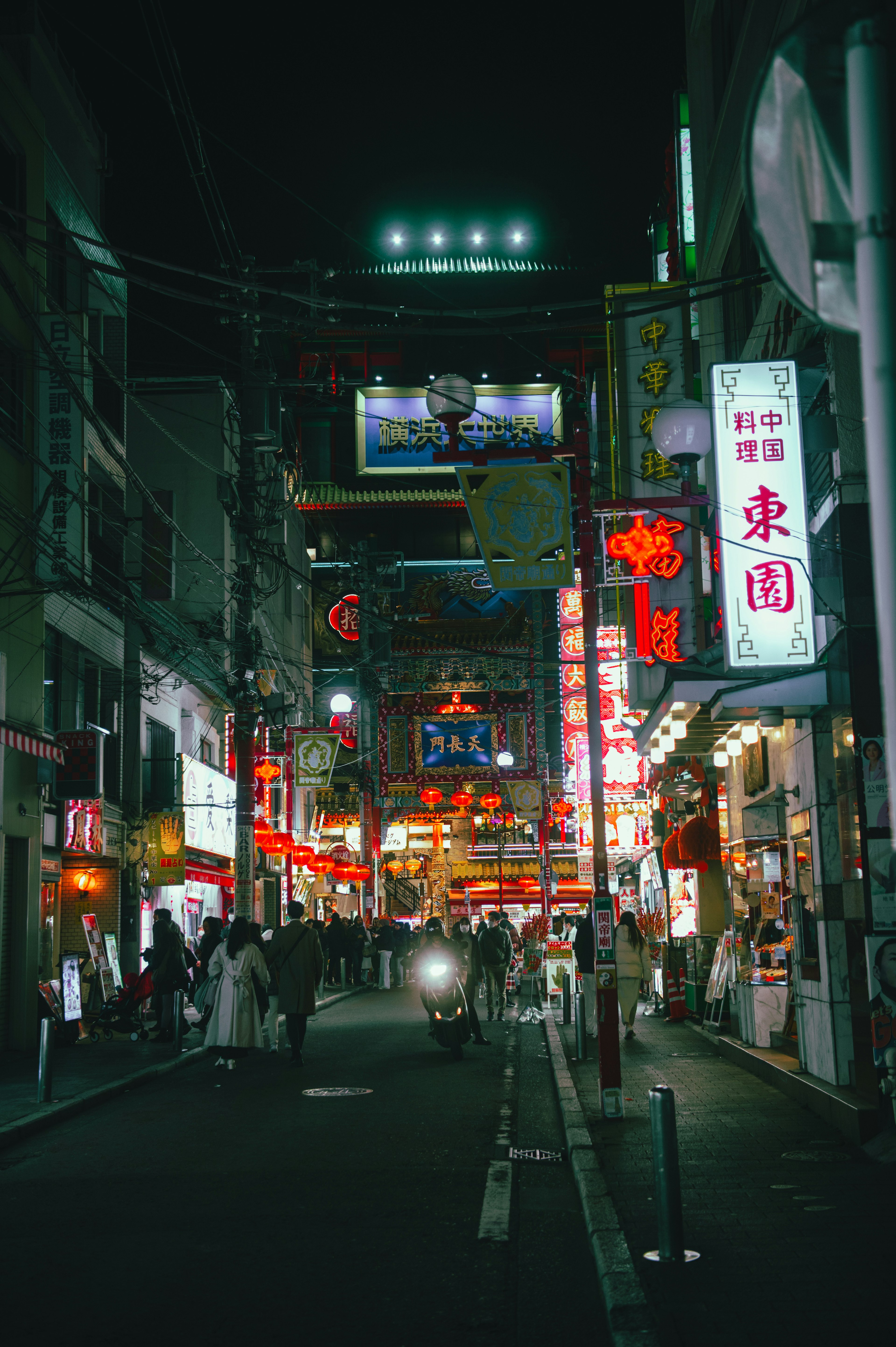 Bustling street at night with bright neon signs and lively atmosphere
