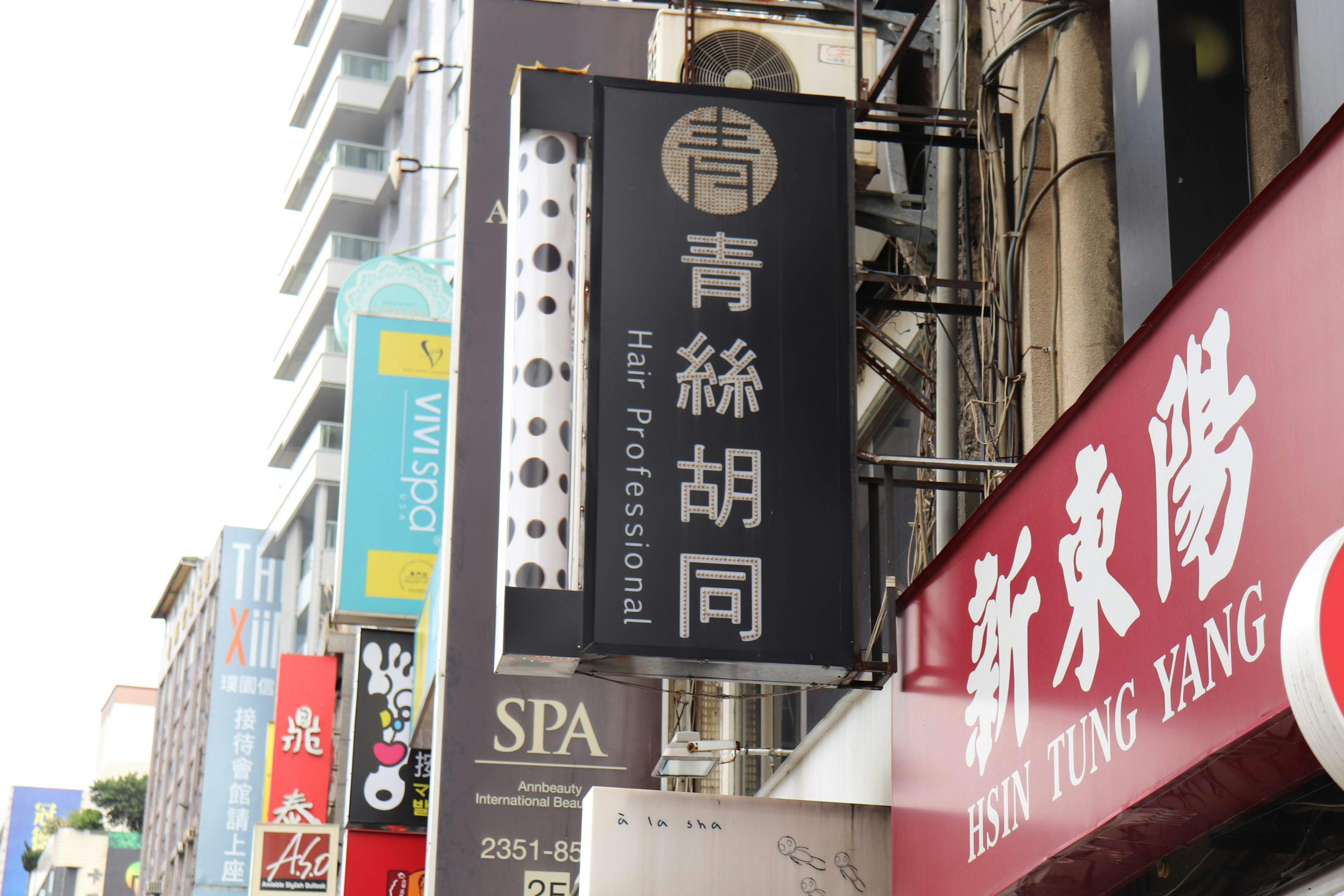 Cartel de Qing Si Hu Tong en una bulliciosa calle comercial