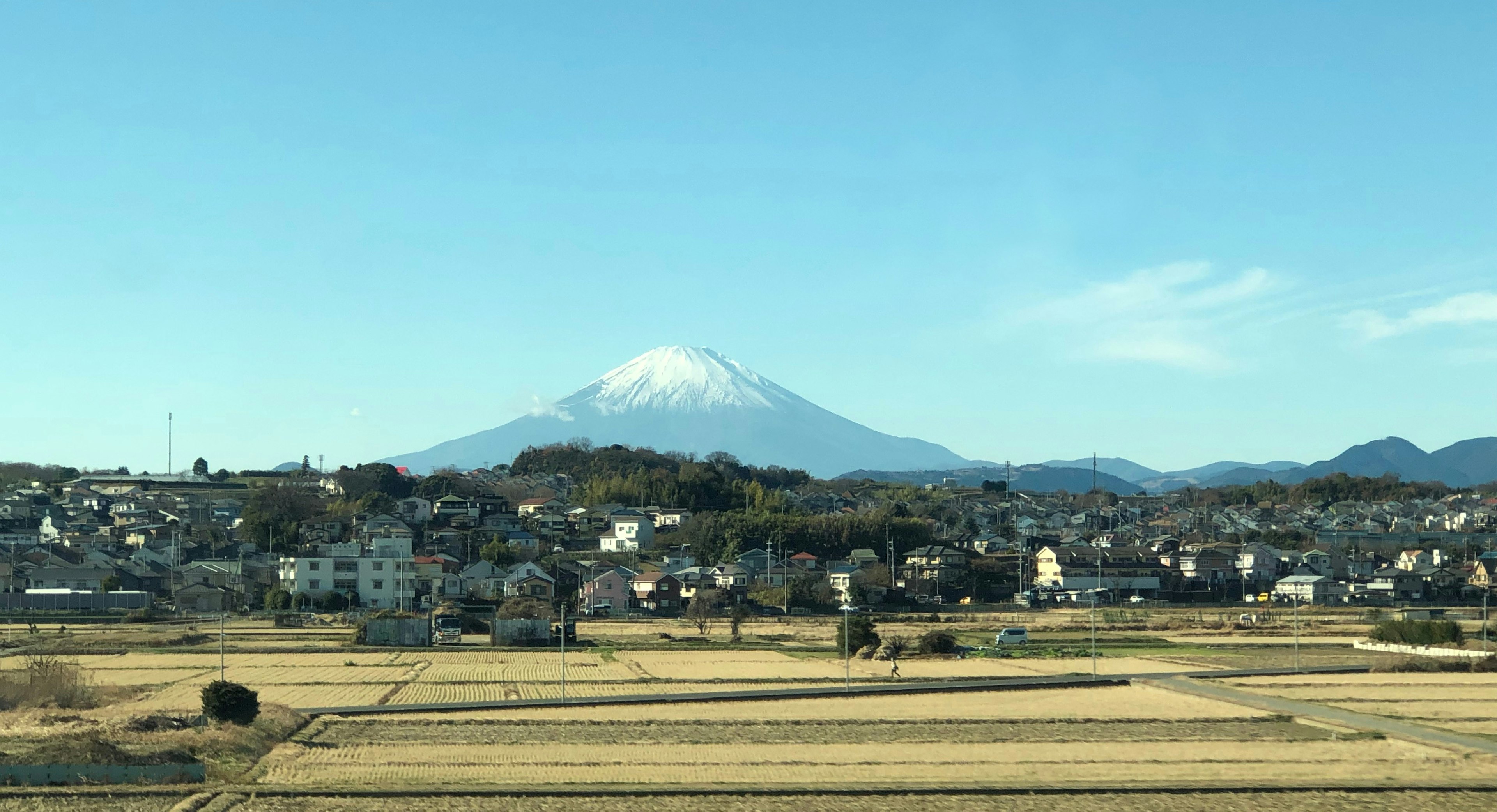 Schneebedeckter Fuji über einer ländlichen Landschaft