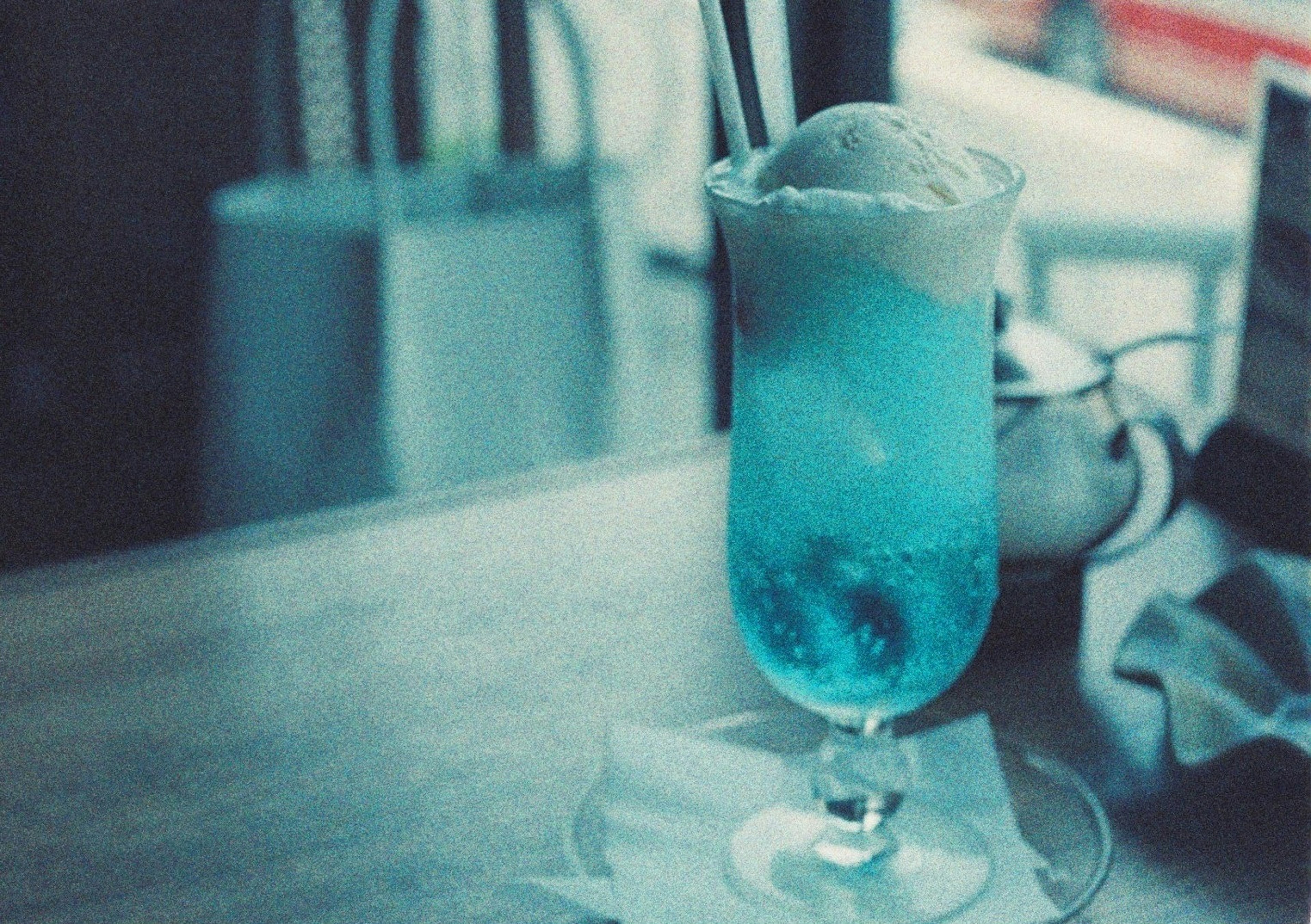 Glass of blue drink topped with ice cream