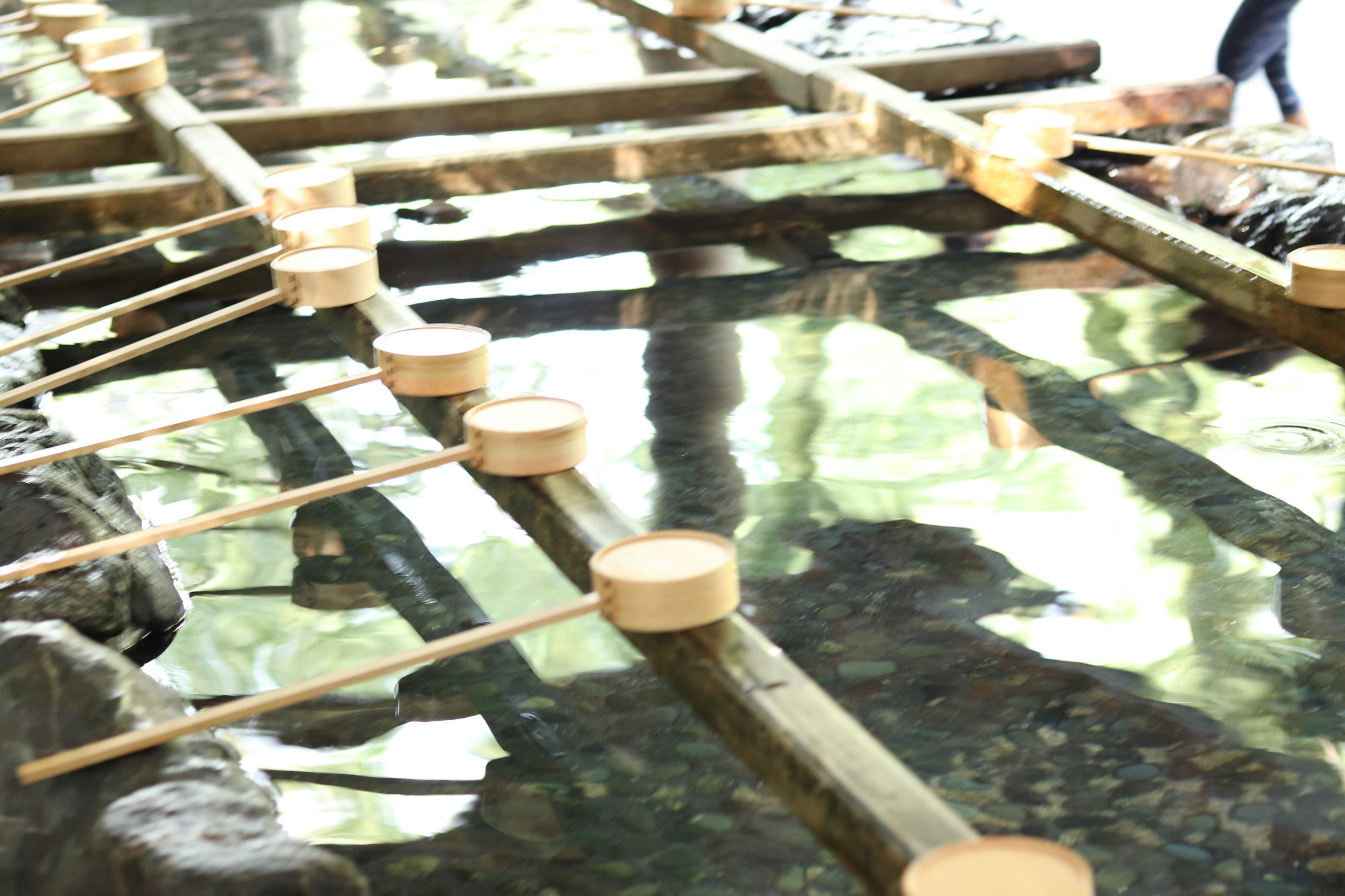 Wooden ladles and bamboo structure in clear water