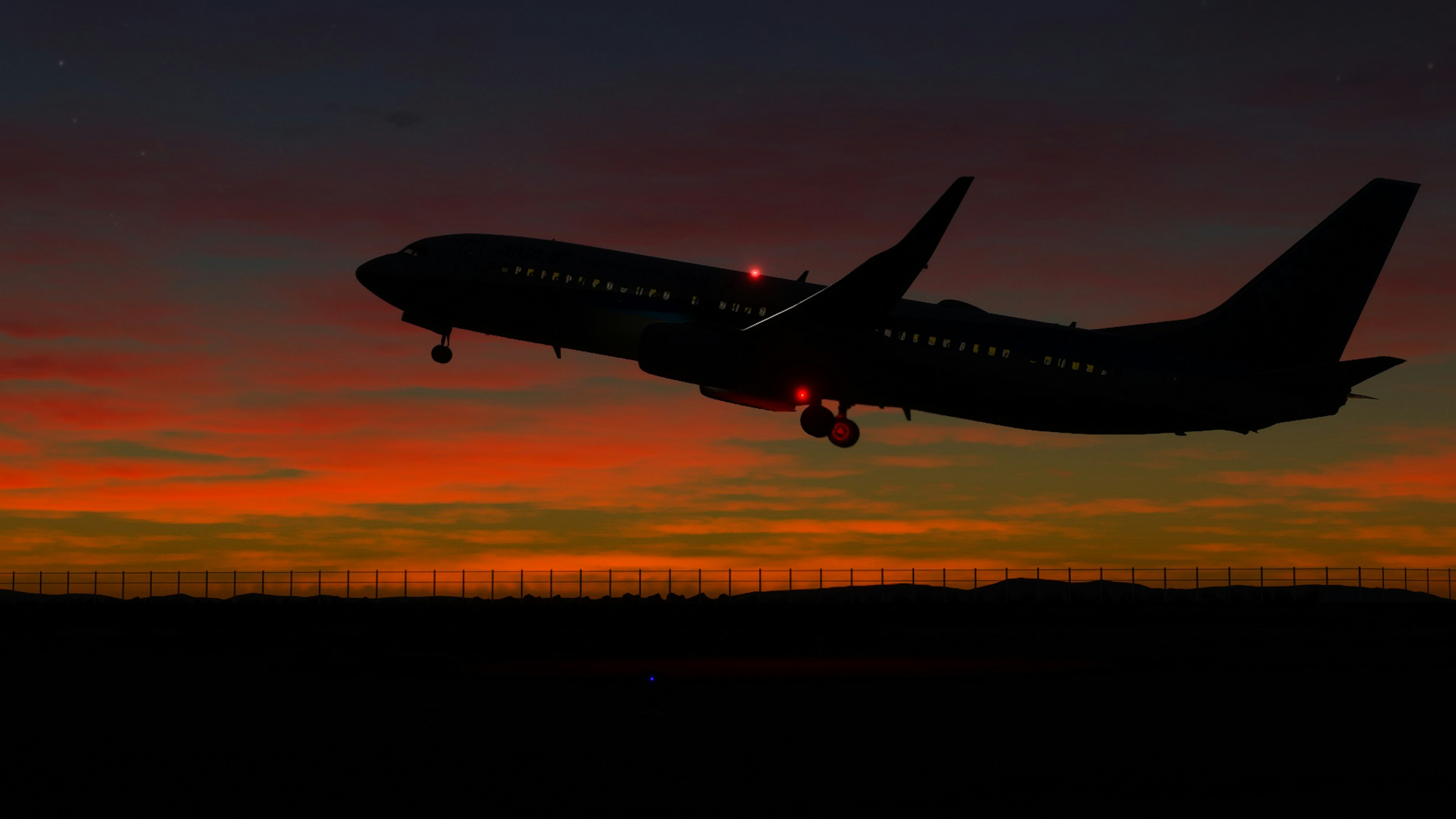 夕焼けの中を飛ぶ飛行機のシルエット