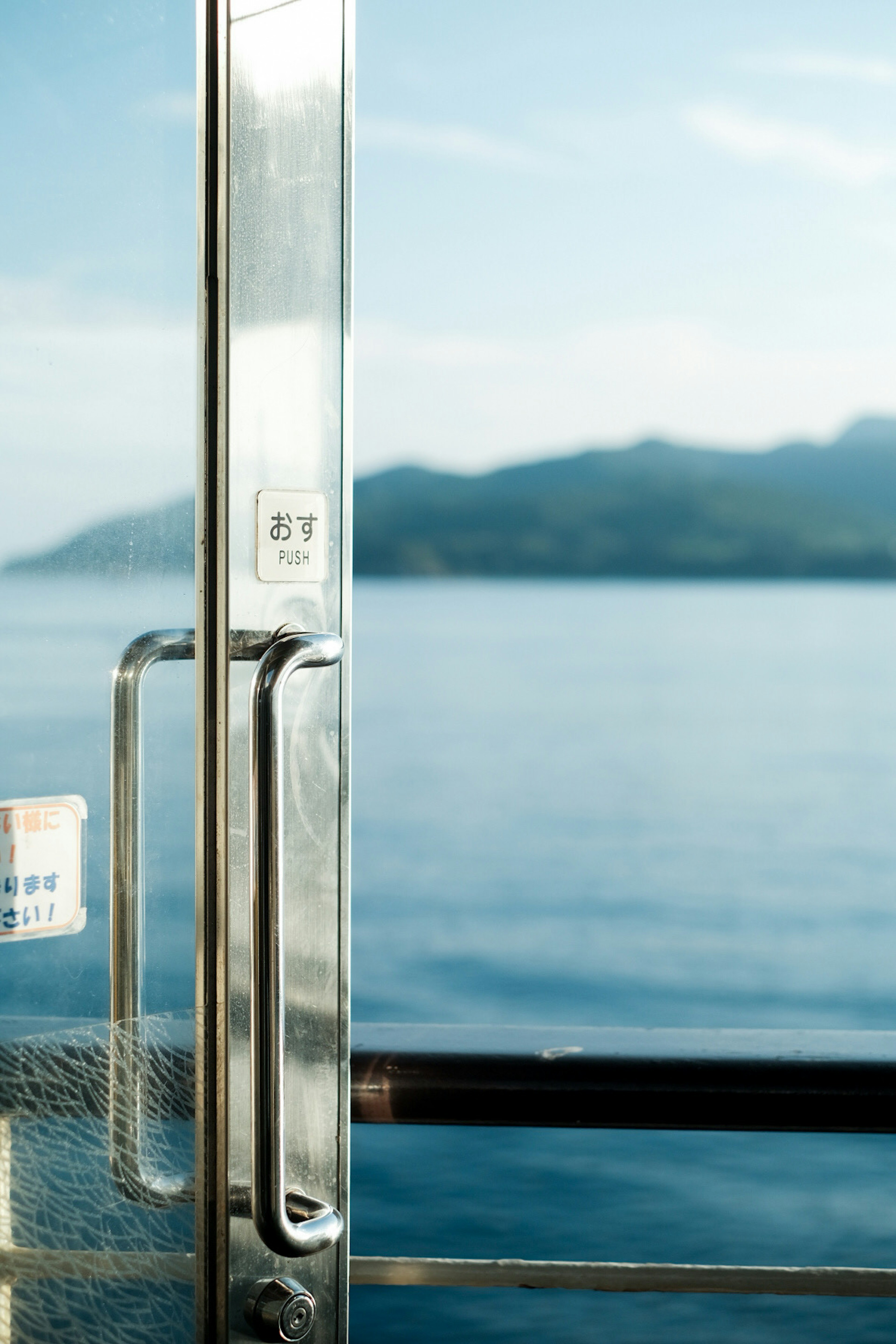 Close-up of a metal door with a sea view in the background